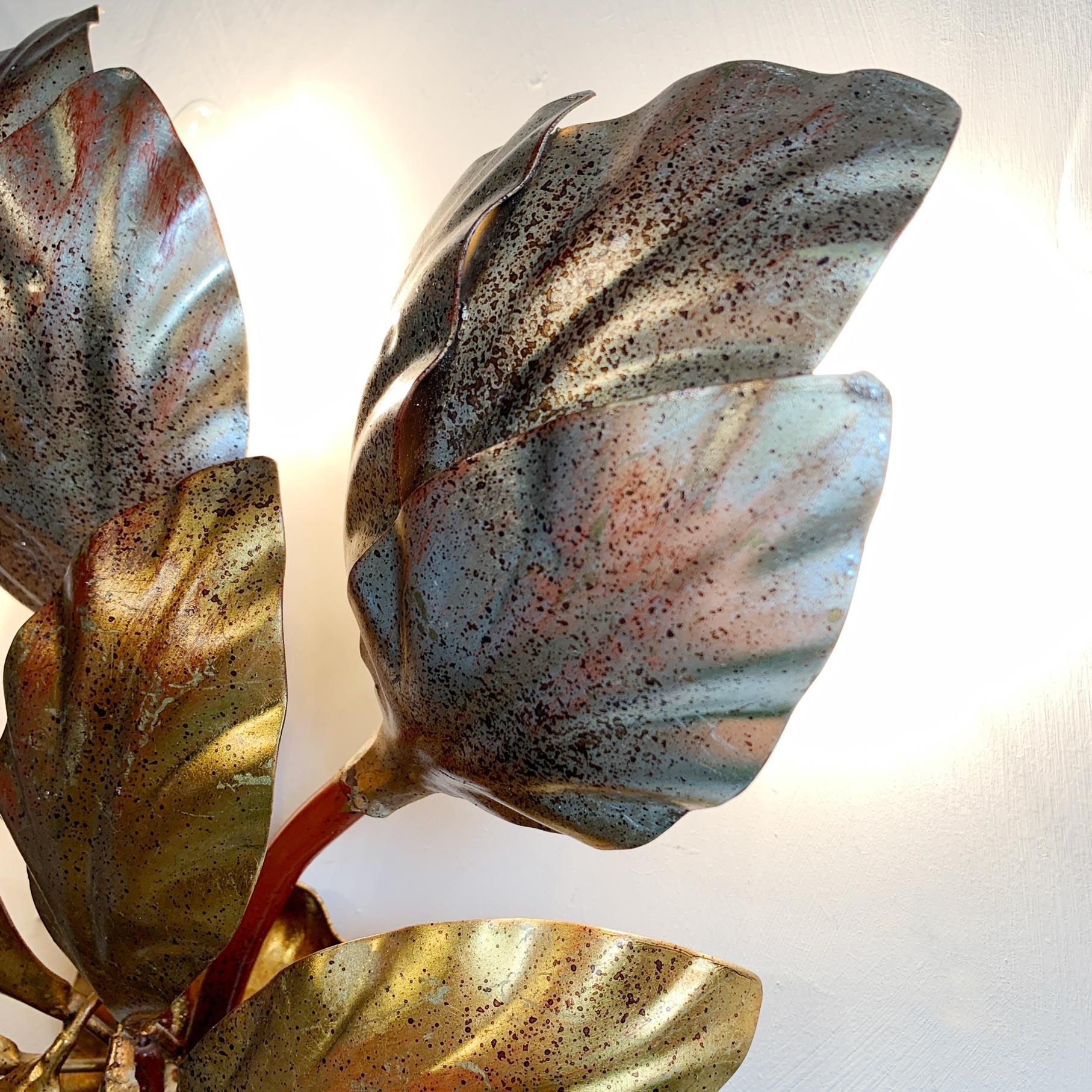 Hans Kogl gilt and silver leaf wall light, 3 lamp holders sit behind large decorative leaves.

Measures: 39.5cm width, 36.5cm height, 10cm depth.

The light is wired and in full working order, but as with all our lighting we would always suggest