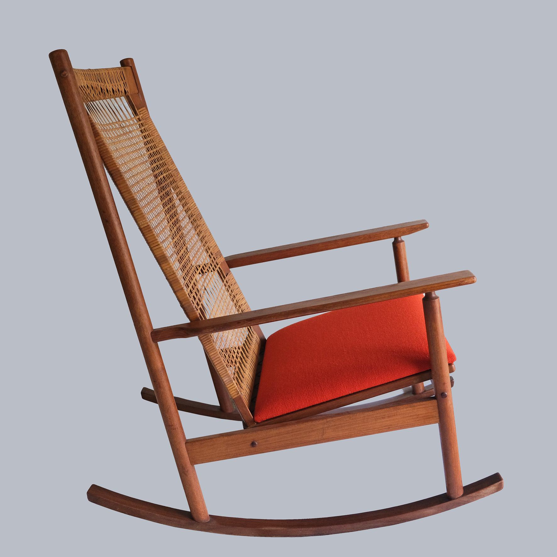 The frame made of teak, the back woven in cane, the seat upholstered with an orange fabric.
Stamped « JK, Made in Denmark », with a « Danish furniture makers control » sticker.
Produced by Juul Kristensen. 
Denmark.
1960s.
 