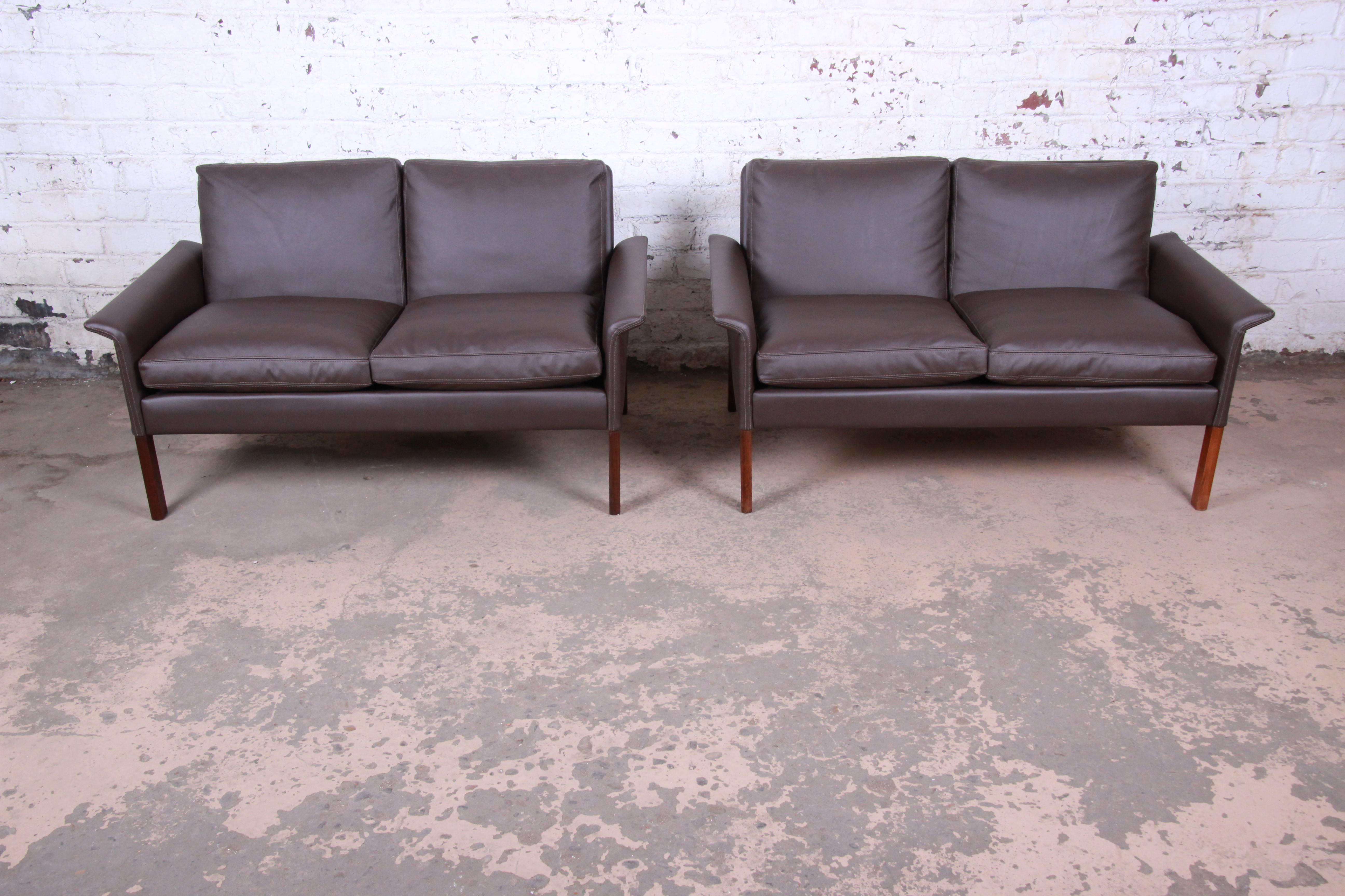 An exceptional pair of midcentury Danish modern settees or loveseats

Designed by Hans Olsen for Christian Sorensen

Denmark, 1960s

Brown leather and rosewood and down-filled cushions

Measures: 51.13