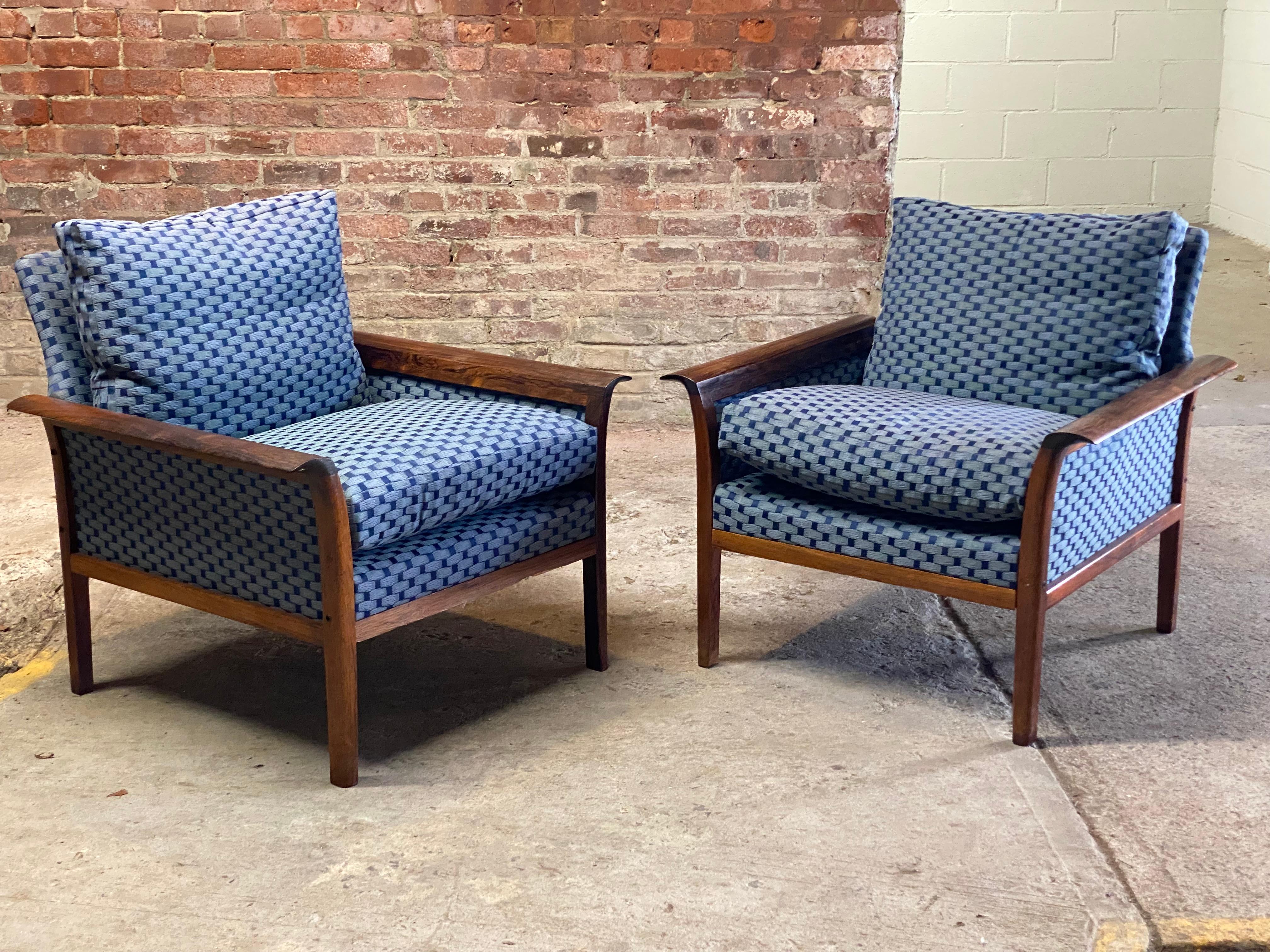 A beautiful pair of solid rosewood and upholstered club chairs from a New York City estate. Designed by Hans Olsen for C/S Mobler, Denmark. The chairs feature a solid rosewood frame, curved arms and legs. The upholstery consists of a very clean