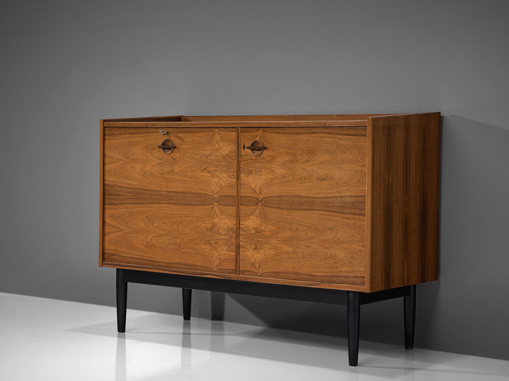 Hans Olsen for Brande Mobler, bar cabinet, rosewood and metal, Denmark, 1960s

A unique piece by designer Danish Hans Olsen provides varied storage facilities designed to be used as a dry bar. On the left bottle holders are integrated into the
