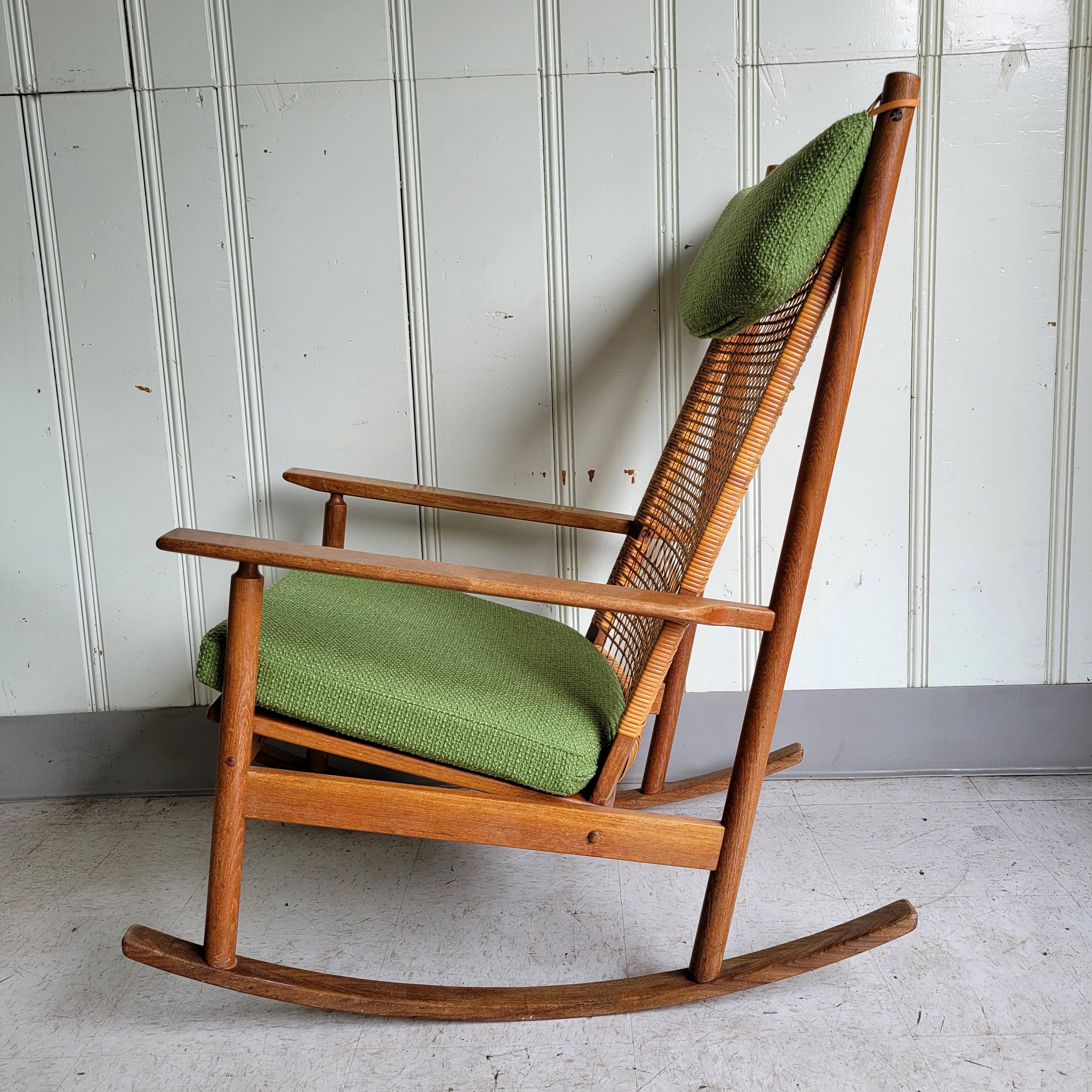 An original Hans Olsen for DUX teak + afromosia wood rocking chair. A beautifully proportioned and designed chair. All the elements work well together. The warmth of the wood, the woven cane, the wool upholstery and the leather accent. 