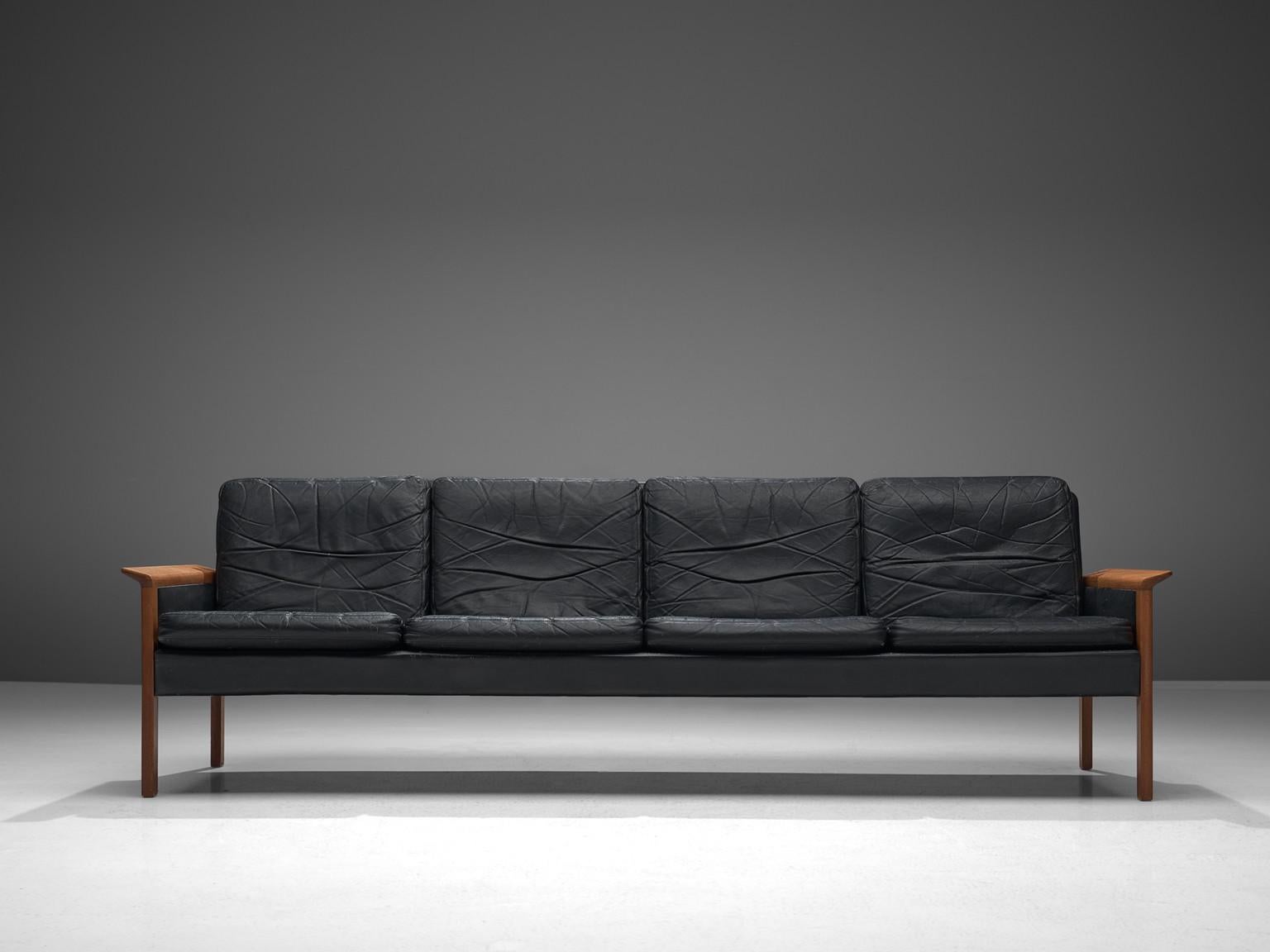 Hans Olsen for Brande, leather, teak, Denmark, circa 1960

This leather four seat sofa is designed by the Dane Hans Olsen for Brande. The sofa is executed in black leather that has beautifully patinated due to age. The sofa has a clean, modest