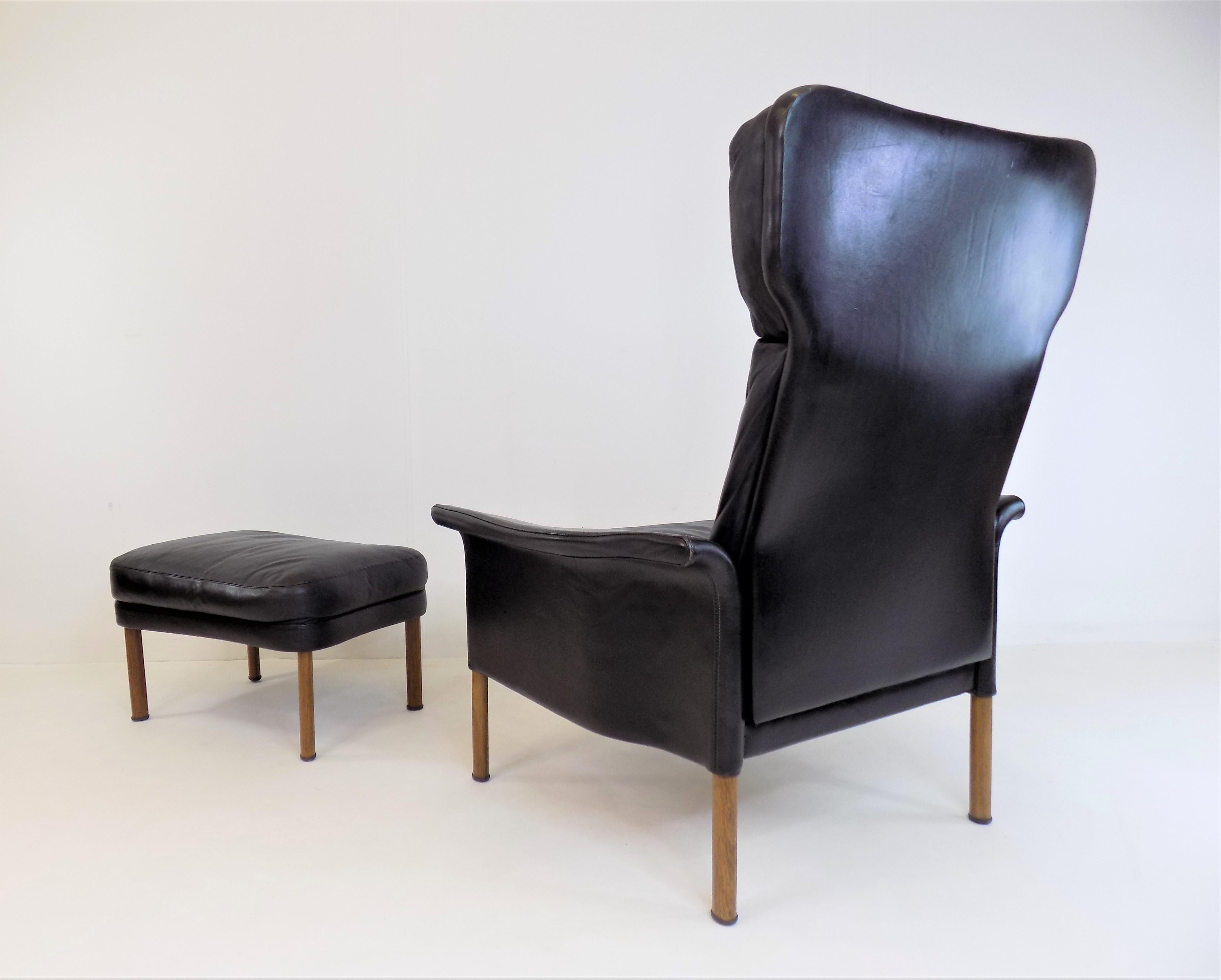 The leather armchair in black leather comes in very good condition with a light patina. The leather of the armchair as well as the Ottoman are soft, without major signs of wear, with a light patina on the corners of the armrest and the backrest. The