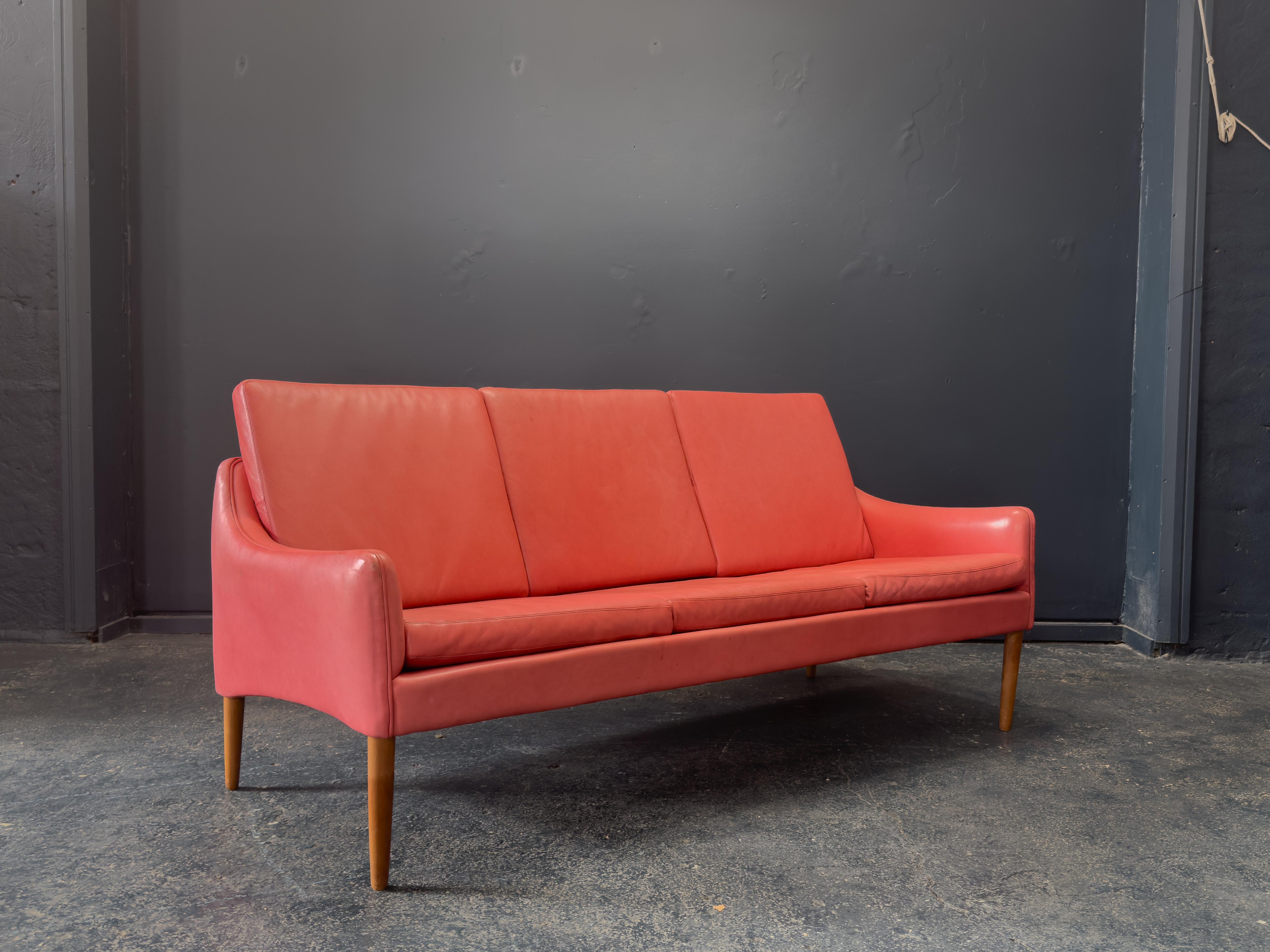 Ce canapé en cuir rouge audacieux et magnifiquement profilé de Hans Olsen illustre son mélange caractéristique de formes sculpturales et de confort ergonomique. Recouvert de cuir rouge richement patiné, ce meuble dégage chaleur et sophistication