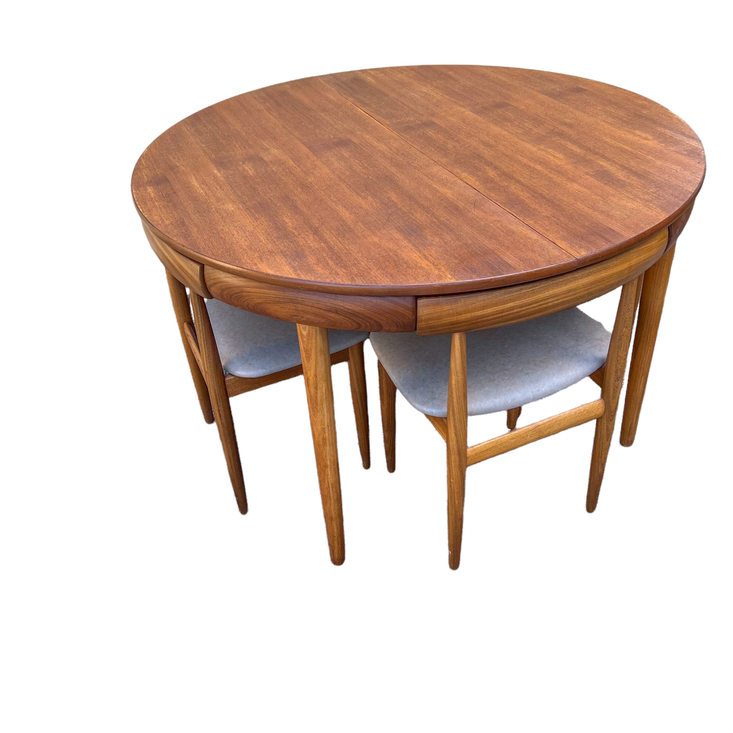 Stunningly designed table and chairs by Hans Olsen for Frem Røjle Møblefabrik made in 1953. The set consists of teak wood and comes with 4 chairs that disappear from the table in the apron, making them invisible and occupying a modest space. The