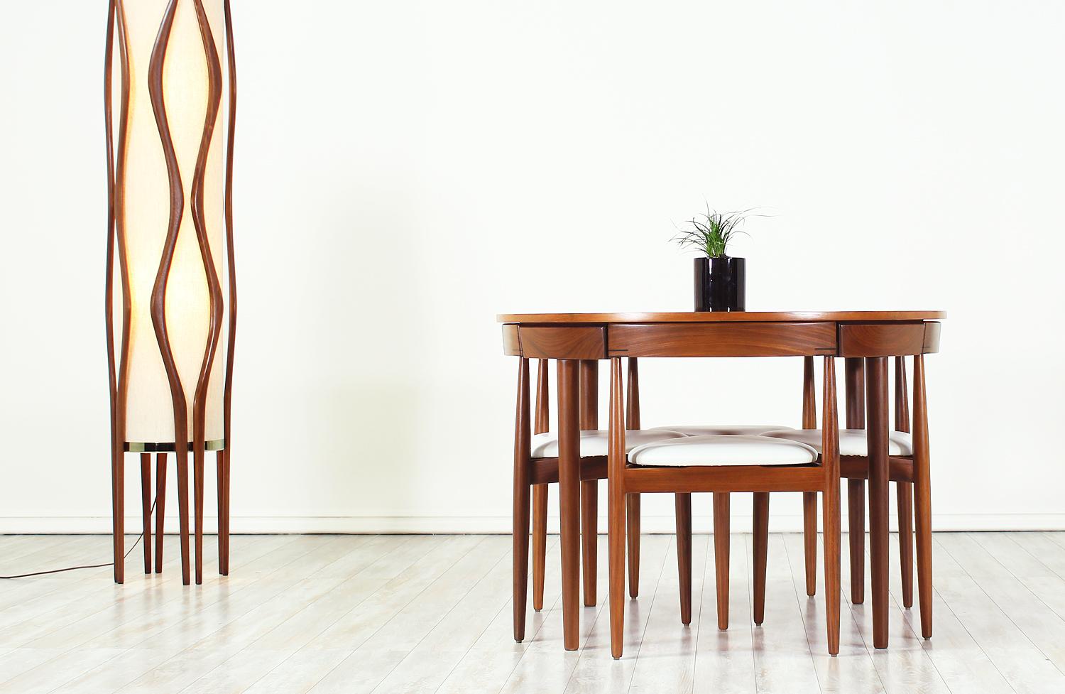 Unique “Roundette” Dining set designed by Hans Olsen for Frem Rølje in Denmark circa 1960s. This striking dining set features a teak wood round table and four dining chairs. The dining chairs seamlessly tuck into the table with their curved back
