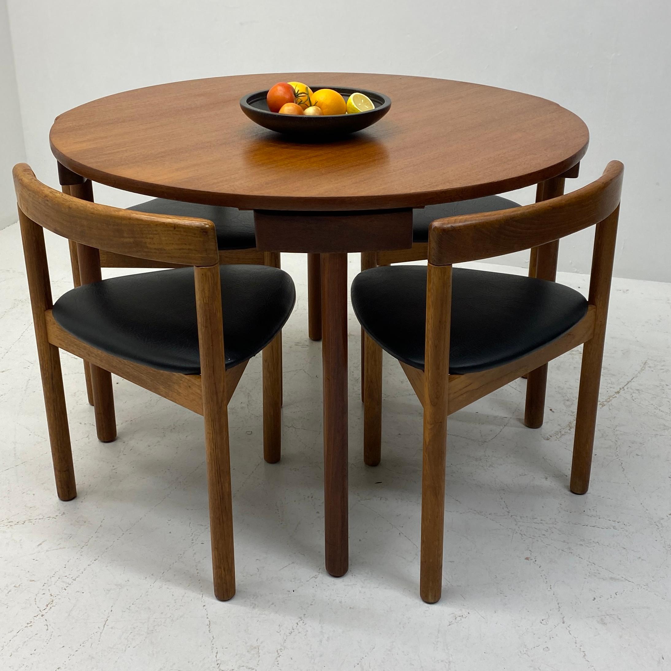 A mid century classic, this Danish dining set is manufactured by A.B.J Denmark, for Hans Olsen. The clever & stylish design makes the chairs disappear in the table with its ingenious design. The chair frames & legs are in solid teak with black vinyl