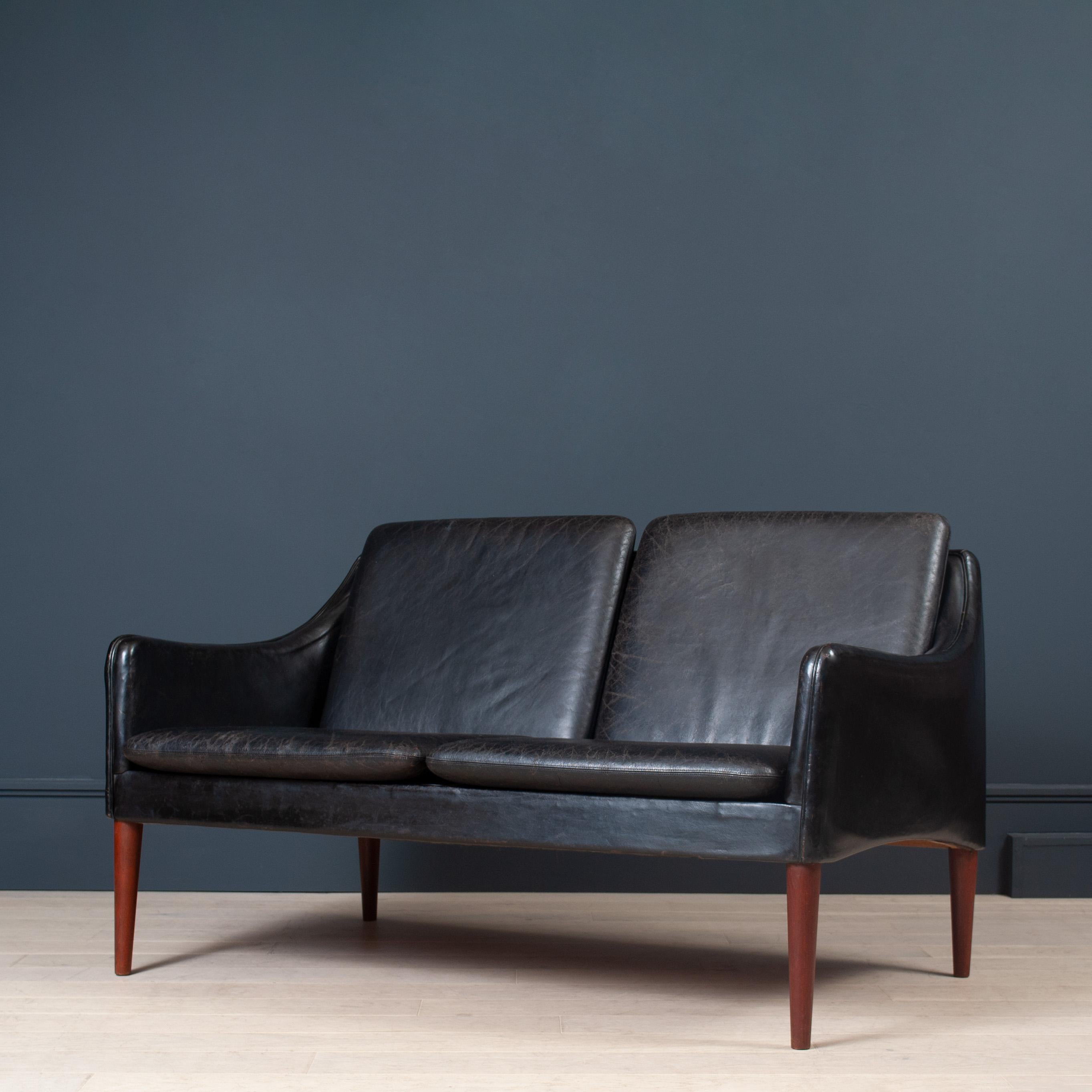 A very early design model 800 sofa by Hans Olsen, Denmark circa 1959. Manufactured by C.S Mobler. 
A wonderfully sculptural and organic design by Hans Olsen. 
Aged black patinated leather on tapered teak legs. 
An impressive piece of Danish design