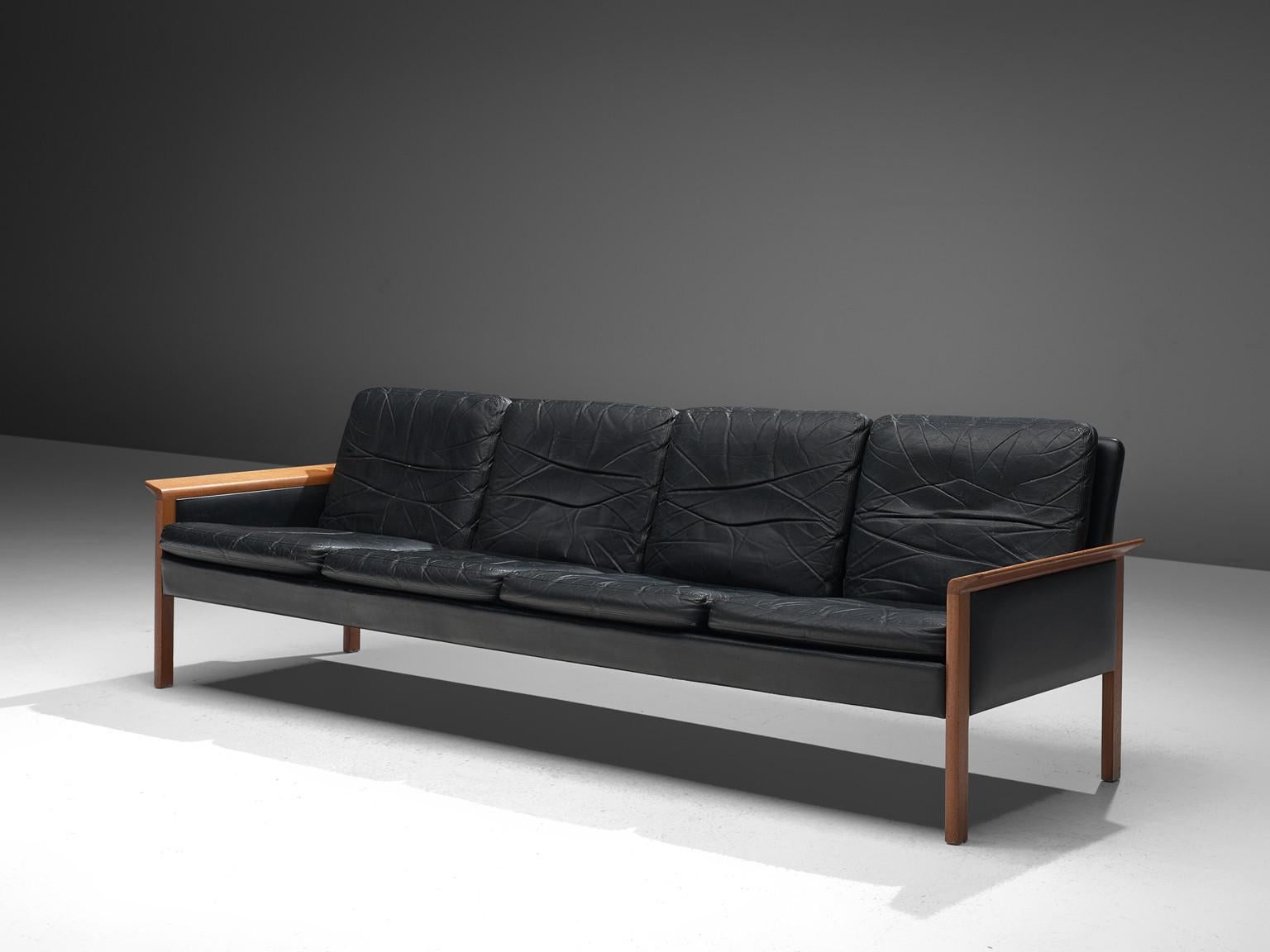 Hans Olsen for Brande Brande Møbelfabrik, leather, teak, Denmark, circa 1960

This leather four seat sofa is designed by the Dane Hans Olsen for Brande. The sofa is executed in black leather that has beautifully patinated over the years.  The sofa