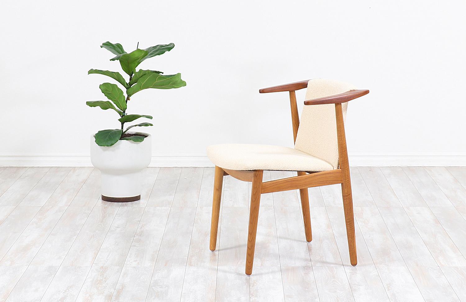 Beautiful modern armchair designed and manufactured by architect and Industrial designer Hans Olsen in Denmark circa 1950s. This iconic chair features an oak and teak wood construction for an exceptional mix of quality materials while providing a