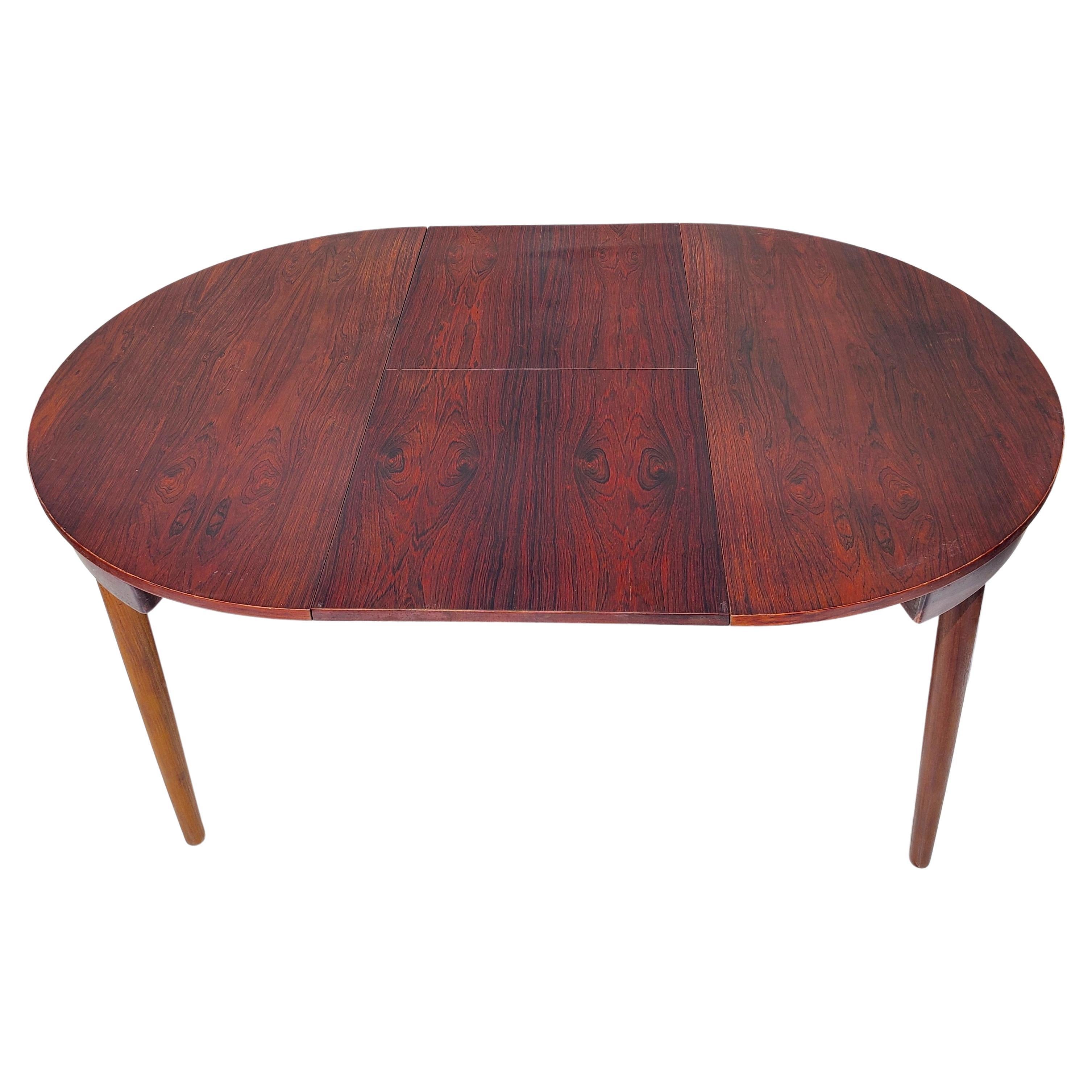 Dining table designed by Hans Olsen. Made in Denmark by Frem Røjle. Branded. Rosewood top. Wenge legs and sliding support structure.
Just over 60