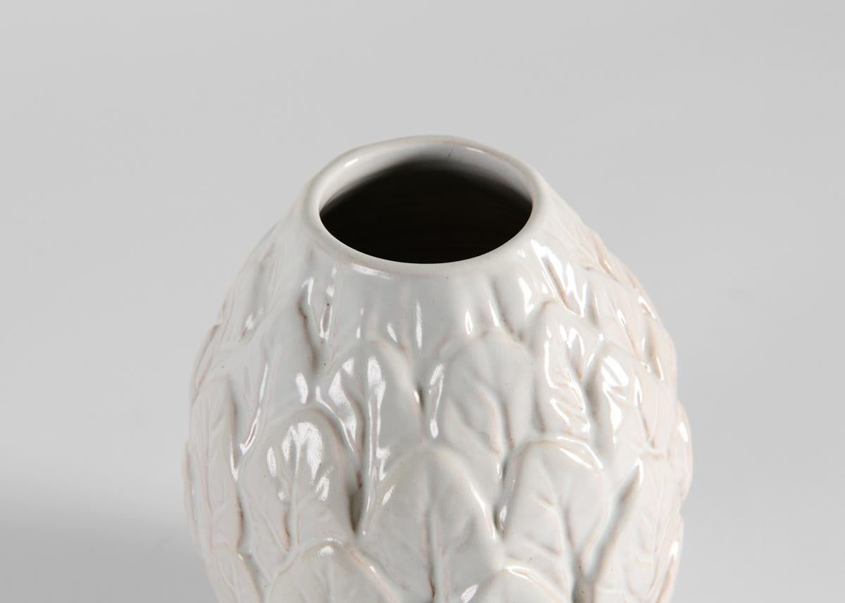 An ovoid vase, the overall leaf pattern is thickly glazed in white.

Stamped.
