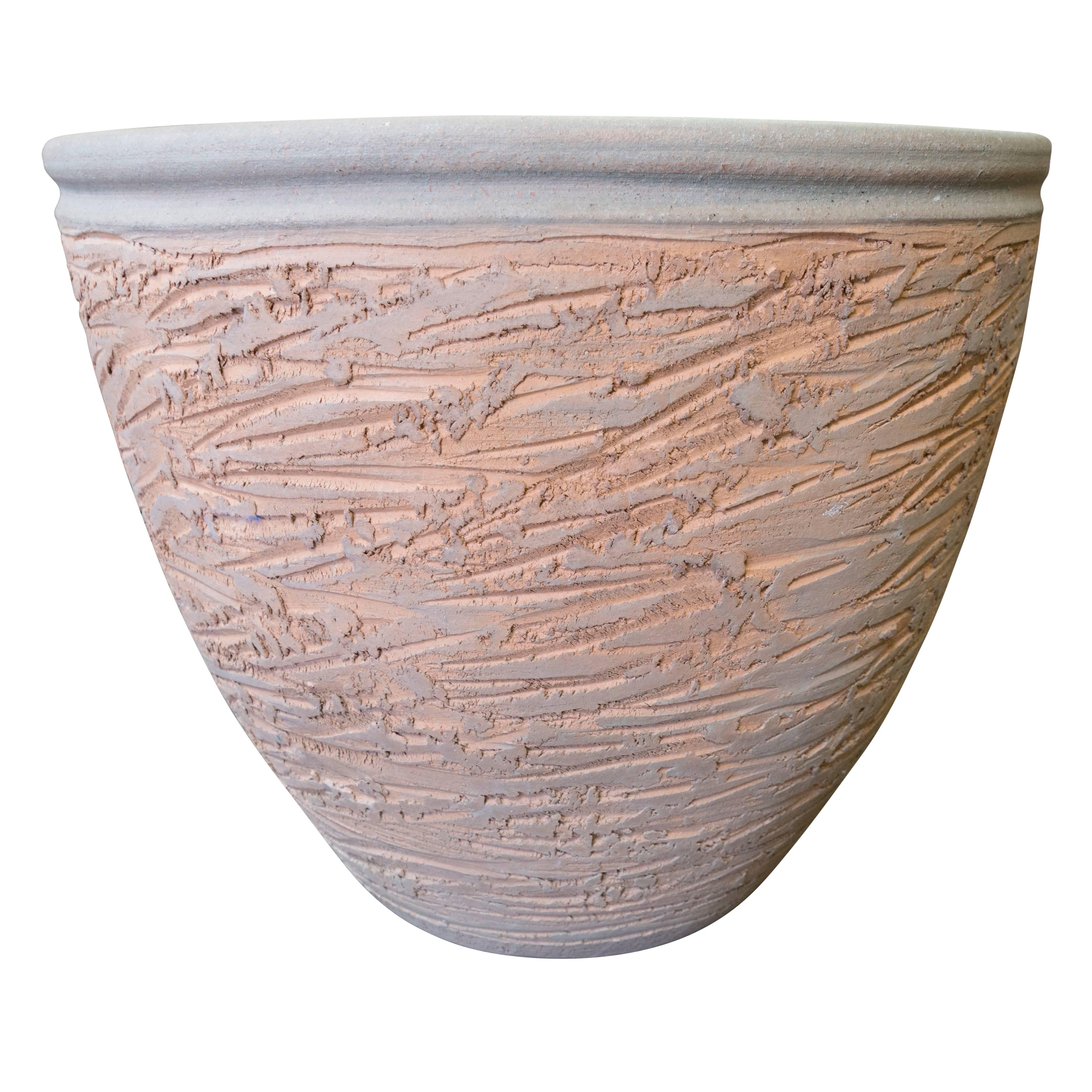 Featuring a scrape pot style body in an unusual bright orange-ish terracotta color with a light blue rolled rim. Art for the home or garden by Hans Sumpf.