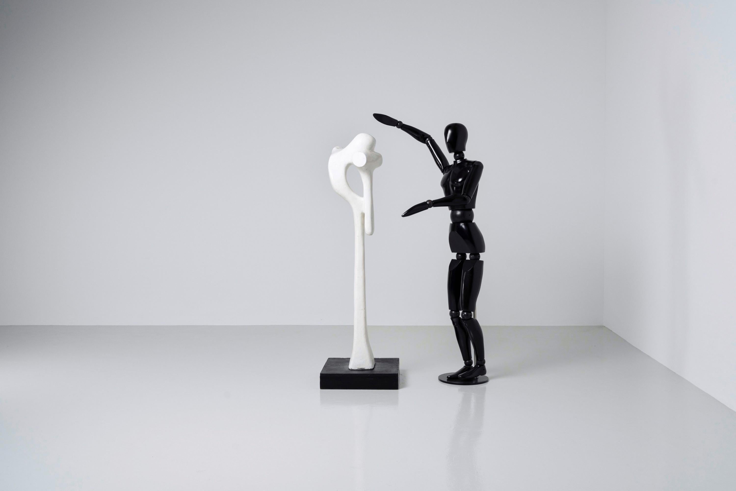 Intruiging and tall sculpture made by Dutch artist Hans van Eerd in 1974.  The sculpture is made of painted plaster and stands on a black ebonized wooden base. This piece looks great in any style of interior but can be used outdoors as well, since