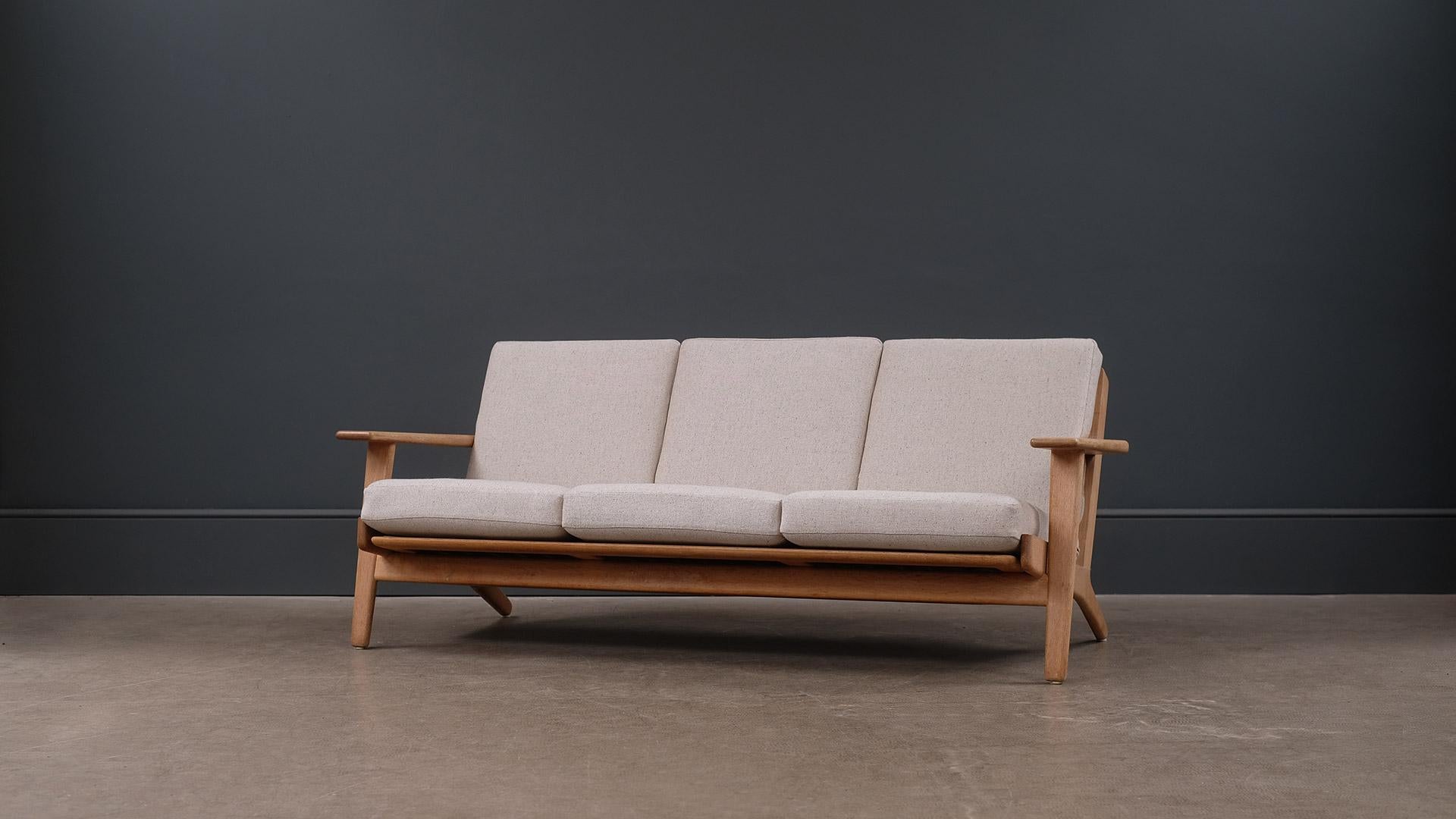 Classic three-seat sofa model GE290 designed by Hans Wegner for GETAMA, Denmark. Solid oak frame with fully reconditioned and reupholstered original sprung cushions.