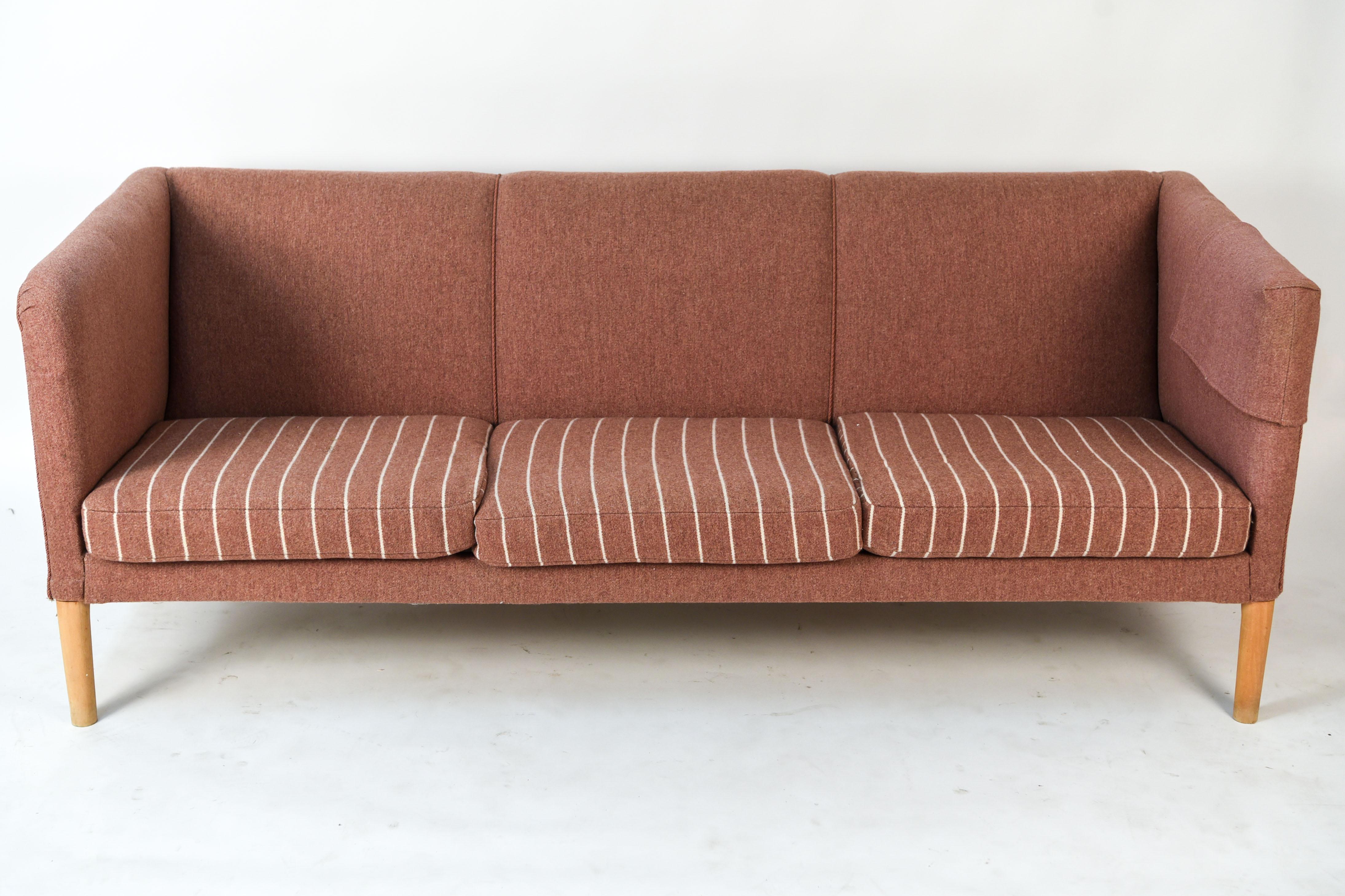 This rare sofa is model AP-18S designed by Hans Wegner and produced by AP Stolen, circa 1955. This is one of Wegner's harder to find sofas, making it a highly desirable piece. This sofa features original wool upholstery over a solid oak frame.