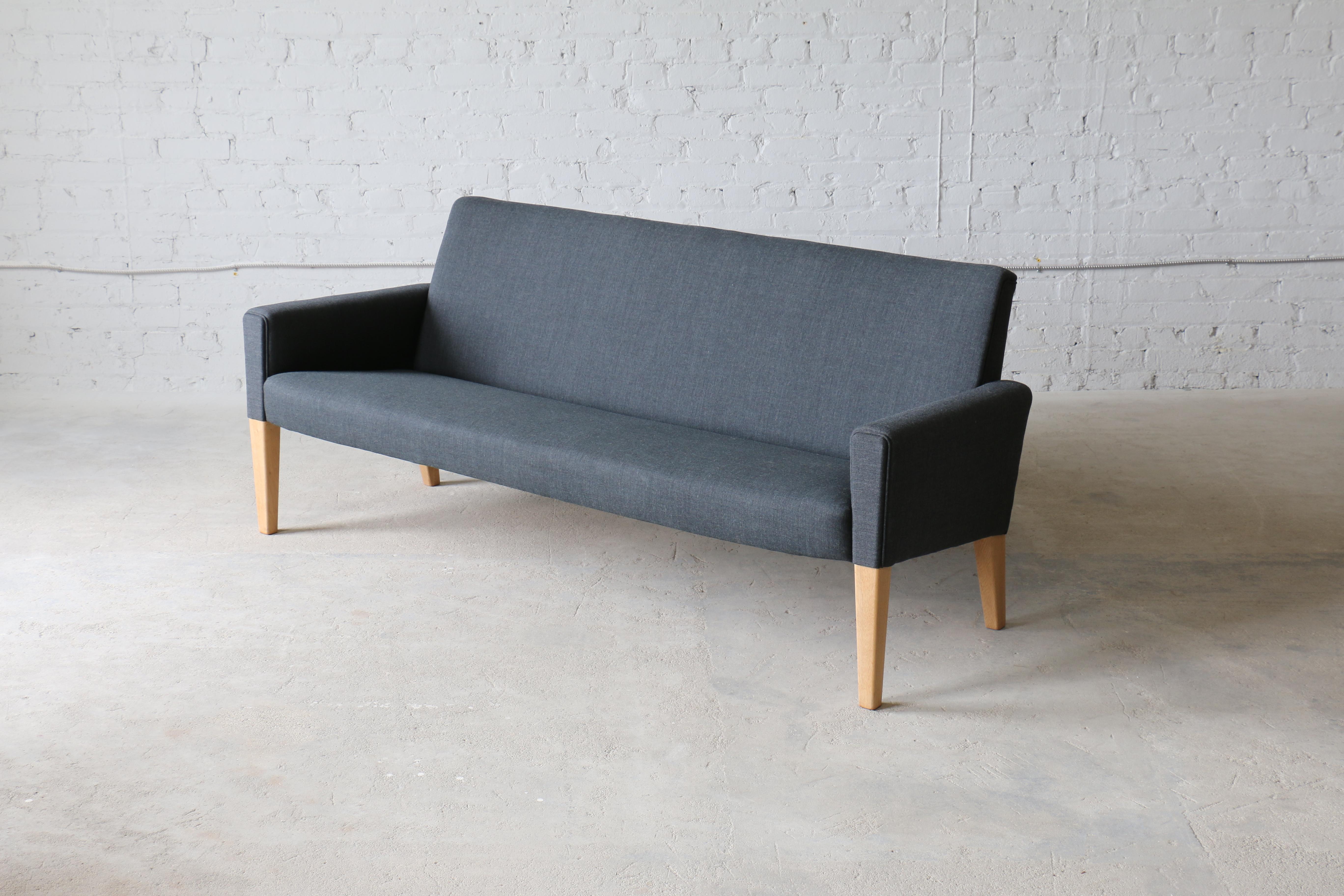 An oak sofa by Hans Wegner for AP Stolen. AP Stolen manufactured most of Wegner's fully upholstered pieces of cabinet maker quality such as his famous Papa Bear chair. This is one of Wegner's more uncommon designs. It is a very sophisticated and