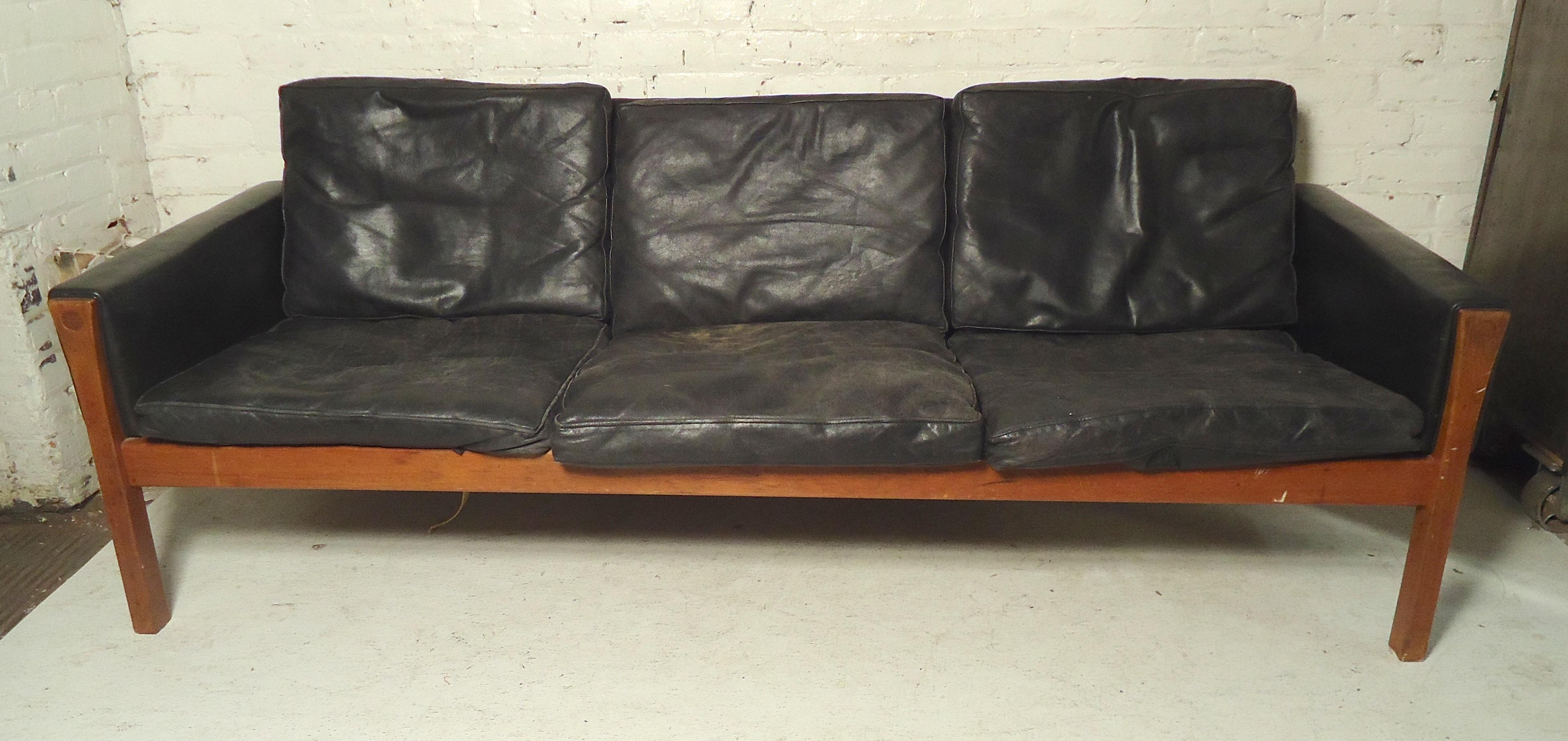 Black leather Danish sofa by Hans Wegner with teak wood frame. Simple Mid-Century Modern lines with comfortable cushioned seating.

(Please confirm item location - NY or NJ - with dealer).
 