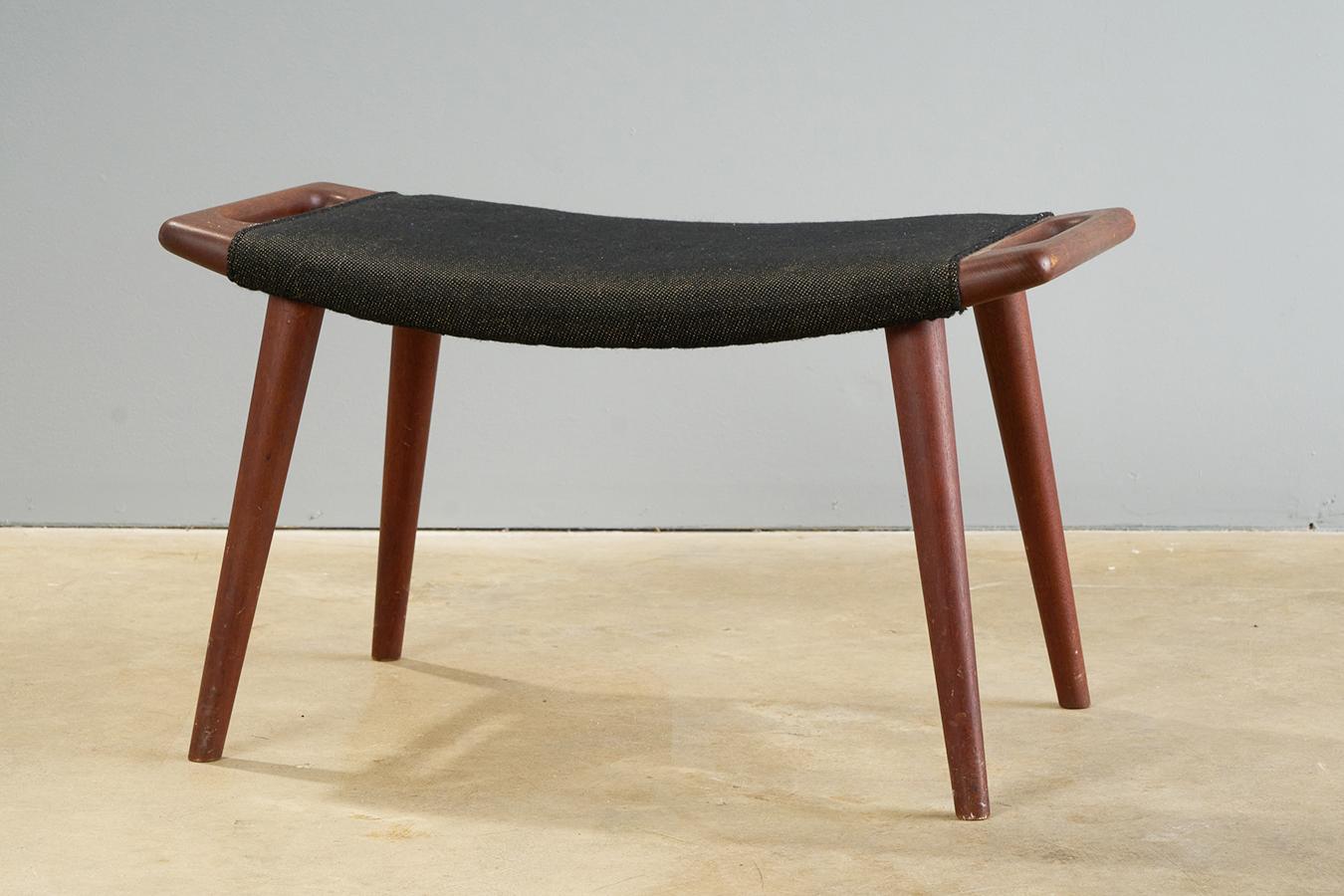 Iconic Hans Wegner foot stool produced by A.P. Stolen, Denmark 1959, distributed by Povl Dinesen Denmark

Stool is in original condition, with teak frame and woven cotton upholstery in unrestored but very good vintage condition. Minor wear to legs