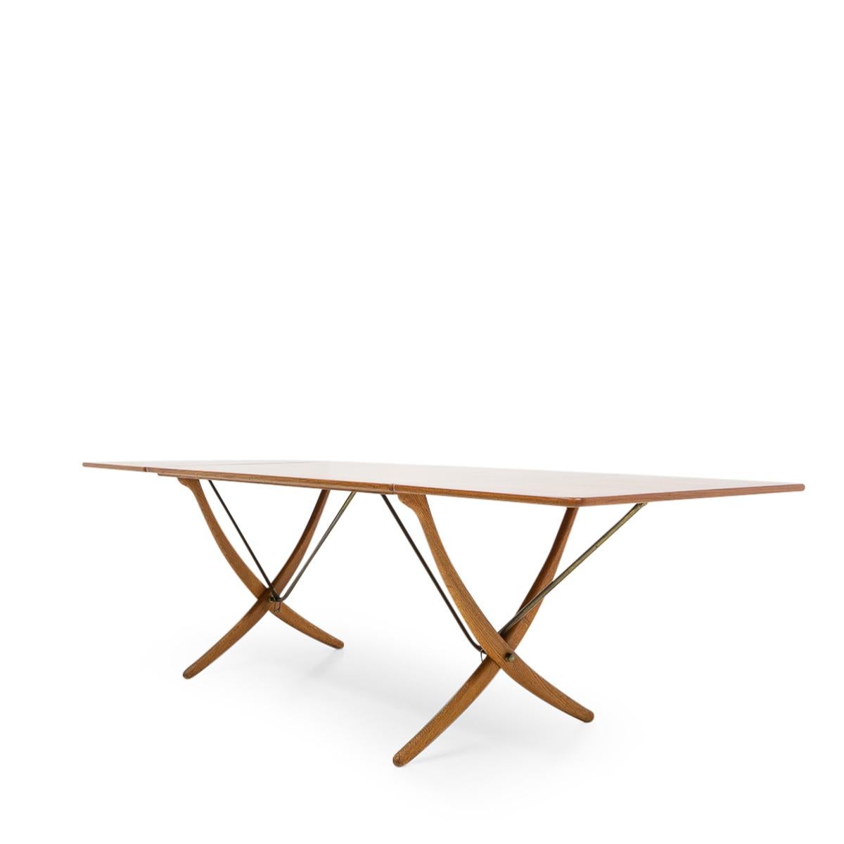 Beautiful “Sabre leg” extendible dining table by Hans Wegner for Andreas Tuck, designed during the 1950s and produced in Denmark. 

The model AT-304 dining table features two foldable extension leaves supported by a construction of brass supports.