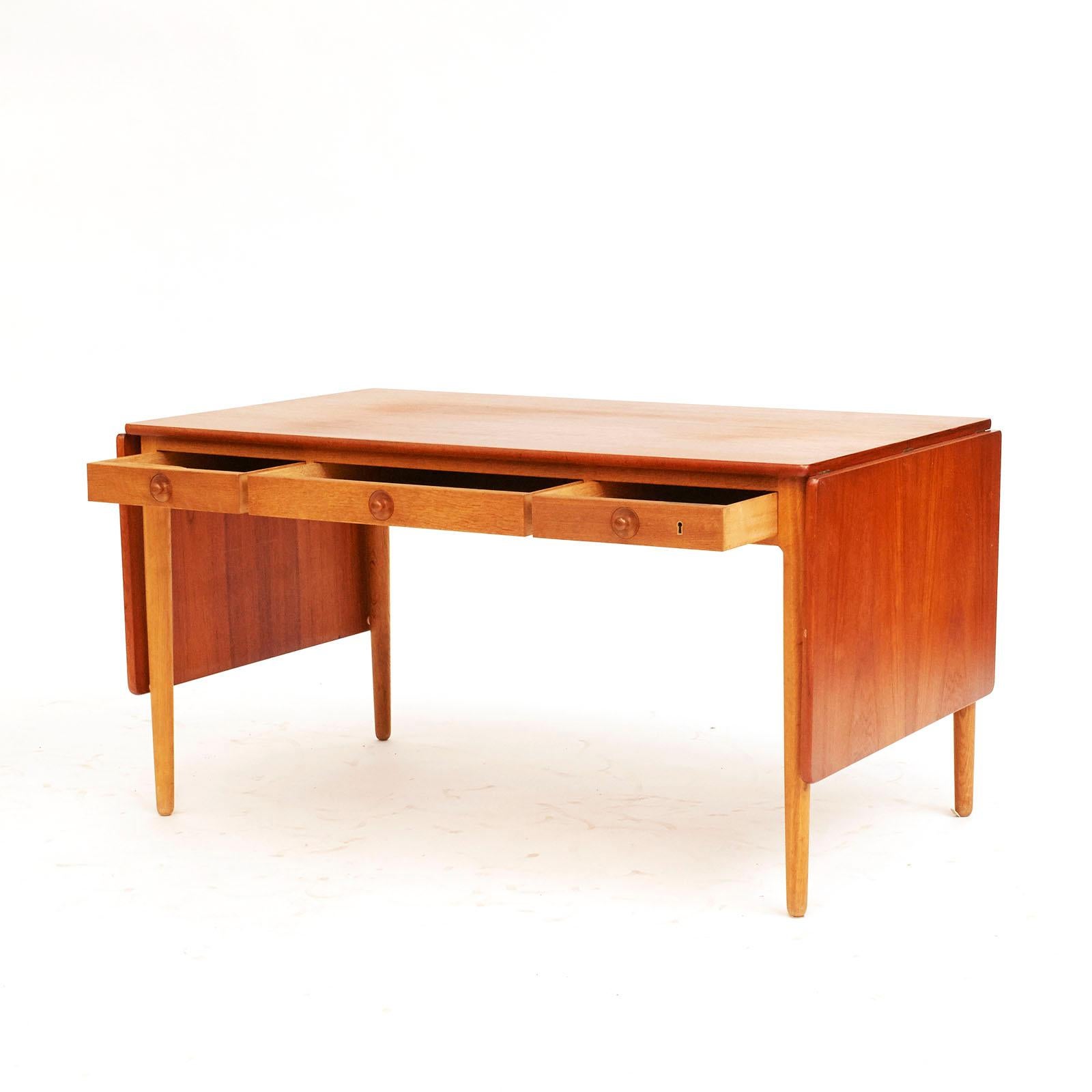 Hans j Wegner ( 1914 -2007 )
Desk/model AT-305.
Oak base with 3 drawers teak top with drop leafs.
Designed in 1955 
manufactured and branded by Andreas tuck