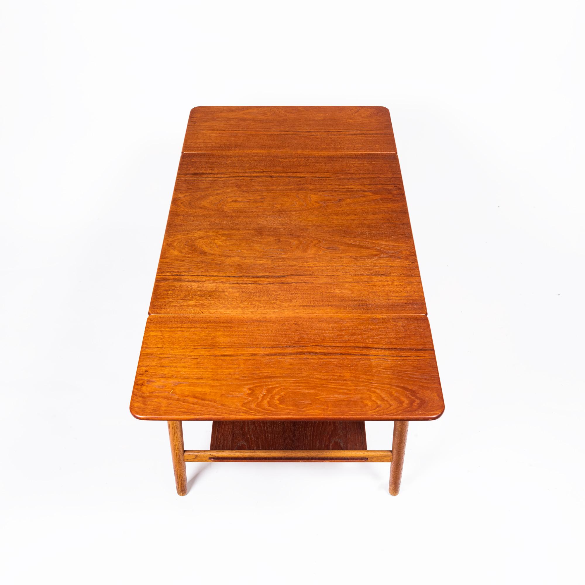 Sewing table AT-33 by Hans J Wegner, made by Andreas Tuck, Denmark, circa 1950s. This sewing table is in solid teak and oak, designed by Hans J Wegner and made by cabinet maker, Andreas Tuck. The table has two drop-leaves, a front drawer with