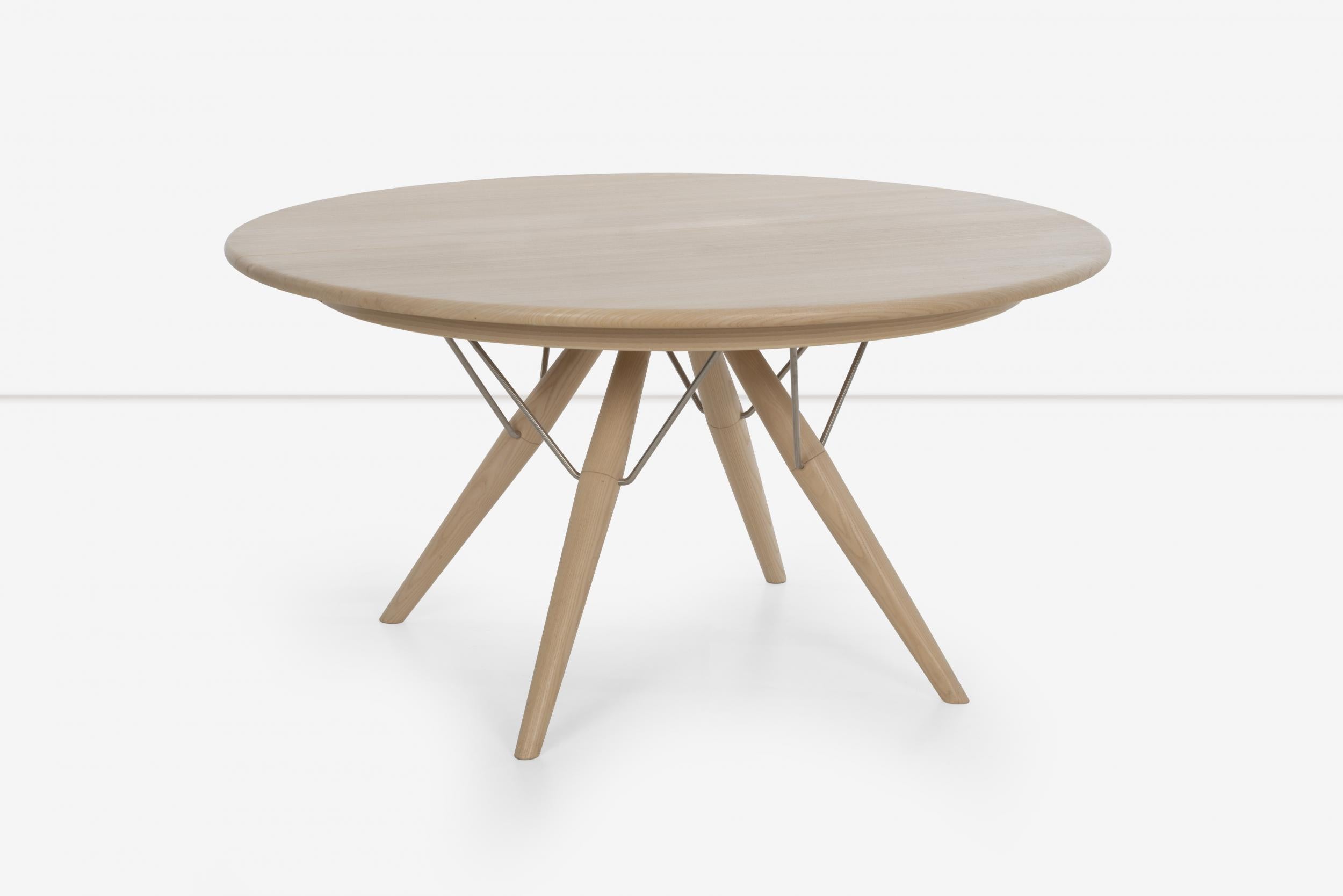 Hans Wegner Atlantide dining table: A construction masterwork, with plenty of knee and leg room for dinners by joining the legs in the center of the top forming a triangular formation with metal supports . Diameter 55.25