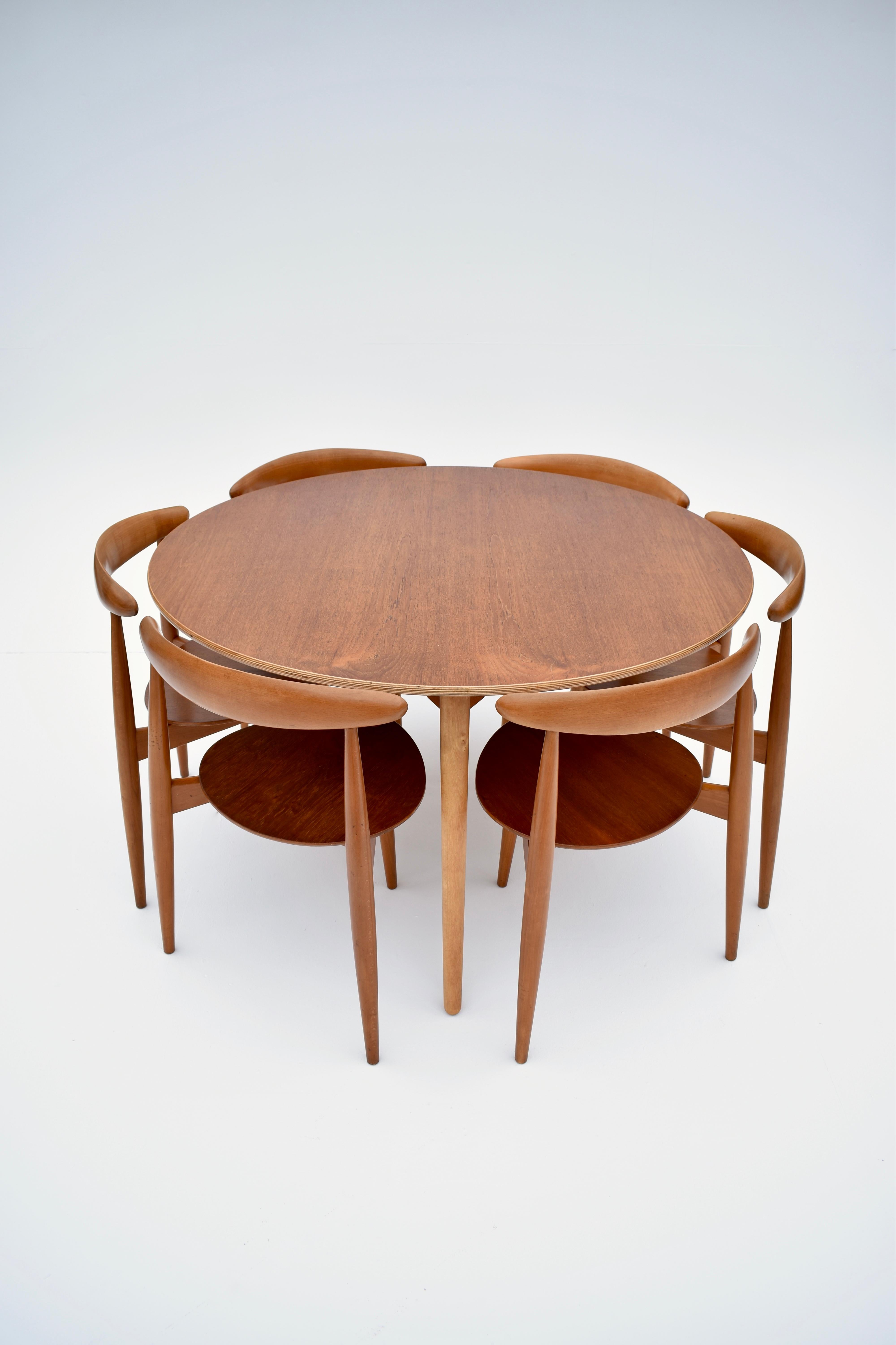 Un ensemble compact de salle à manger très difficile à trouver, conçu au début des années 50 par Hans Wegner et produit par Fritz Hansen, Danemark.

L'ensemble de six chaises en hêtre et en teck s'assoit à plat sous la table, ce qui est à la fois