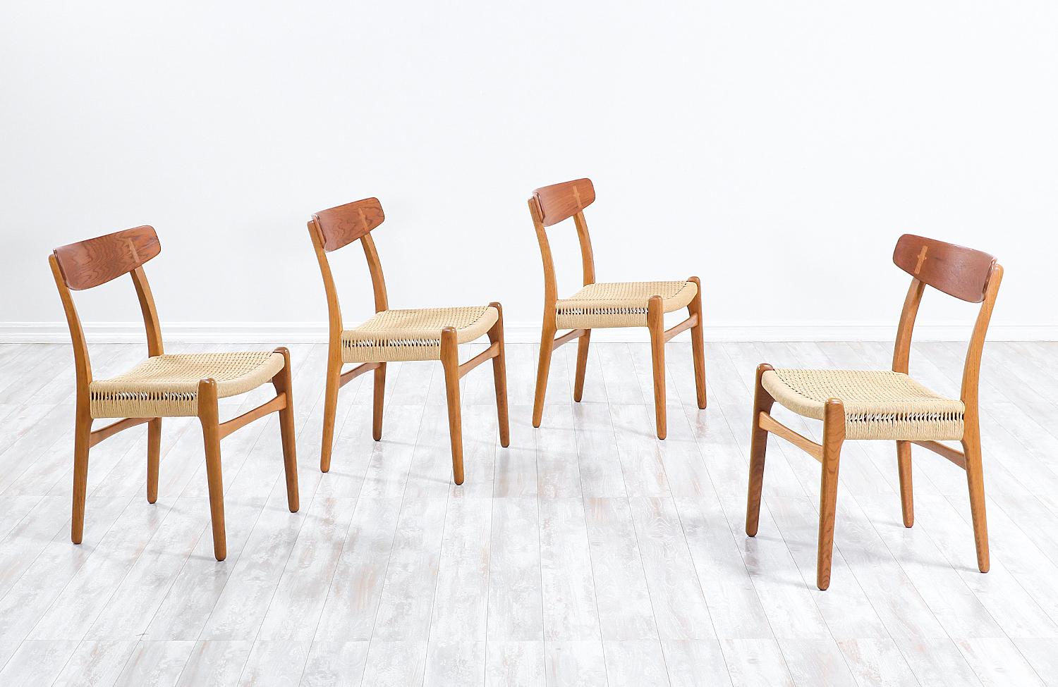 Set of four dining chairs designed by iconic Danish furniture designer Hans J. Wegner for Carl Hansen & Søn in Denmark c. 1950’s. The oak and teak wood frames are in great vintage condition with the Wegnerian joinery details in the backrest, while