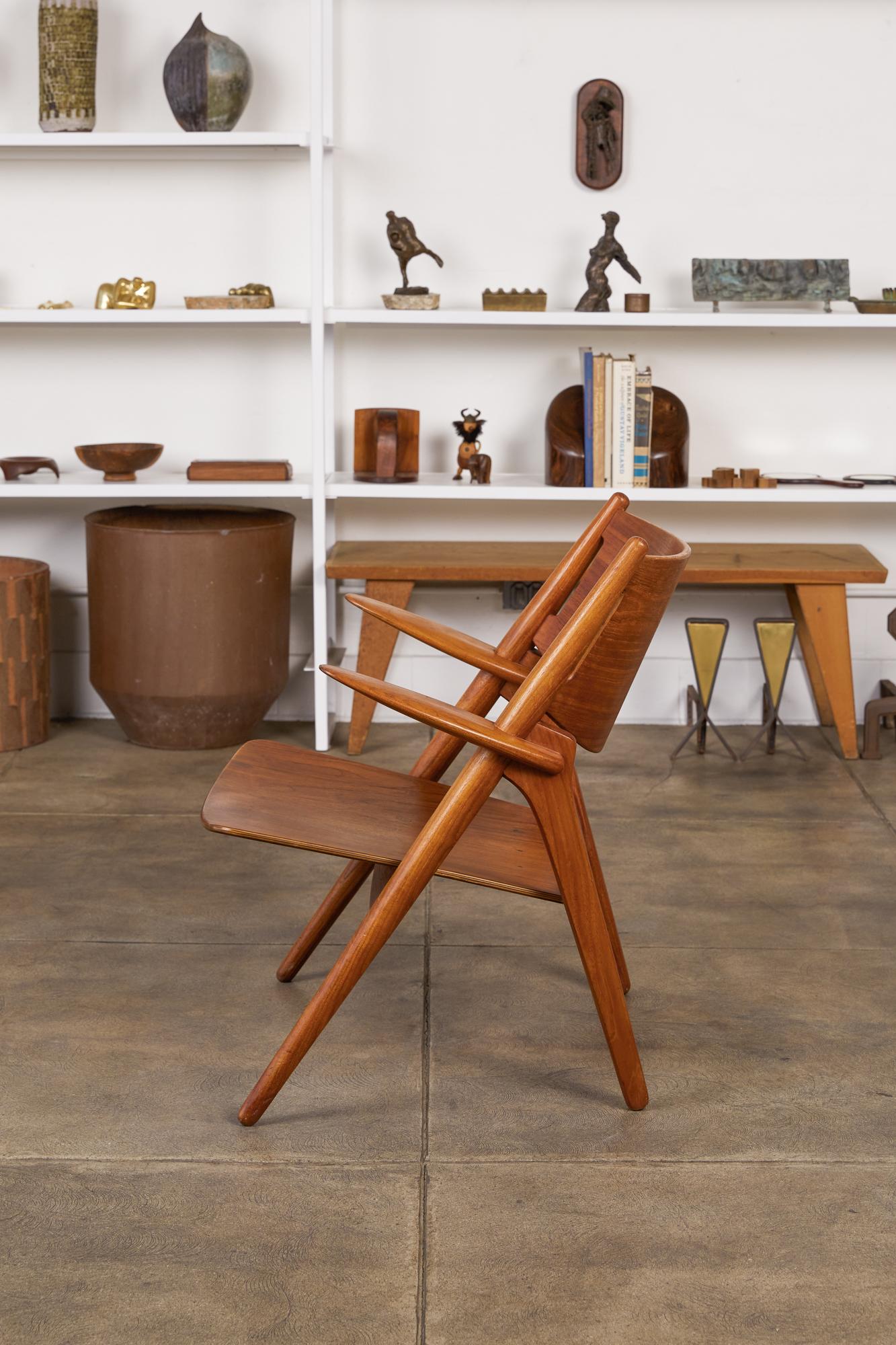 Hans J. Wegner for Carl Hansen & Søn, Denmark, c.1950s. This 1952 design features a teak body with curved plywood seat and back, solid tapering turned legs, and flat armrests.

Heat impressed on underside [Designer - Hans J Wegner - Made in