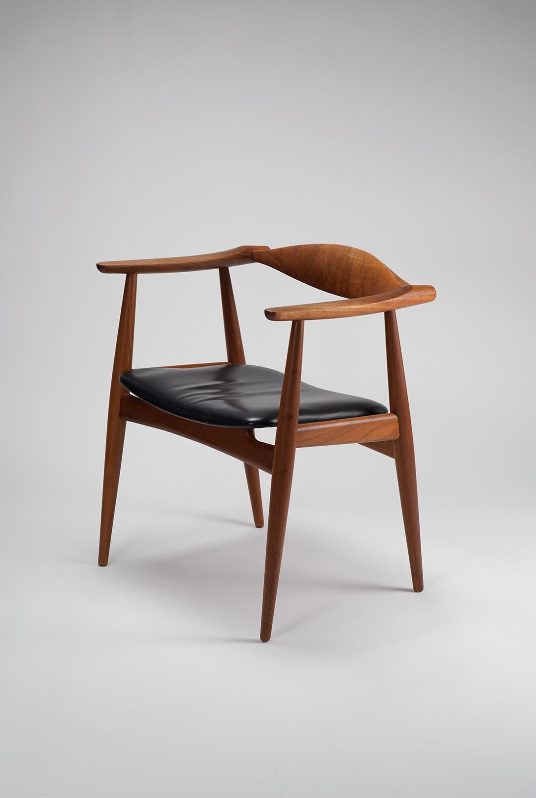 The iconic CH35 armchair in teak by Hans J. Wegner for Carl Hanson and Son. These armchairs were designed and produced in low numbers in the 1950s and are very rare to find today. This example is in great vintage condition with original black
