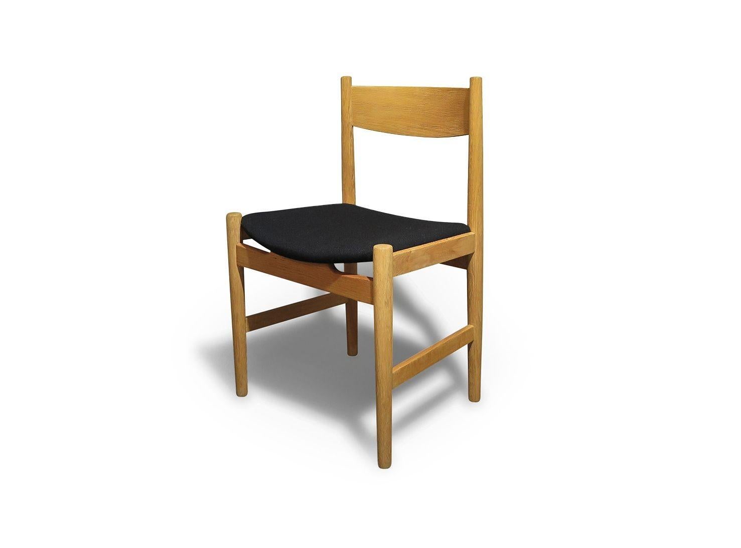 Diese von Hans J. Wegner entworfene Serie von CH38-Esszimmerstühlen wurde 1960 von Carl Hansen & Søn in Dänemark hergestellt. Die aus Weißeiche gefertigten Stühle haben leicht geschwungene Rückenlehnen und behalten ihre ursprünglichen schwarzen