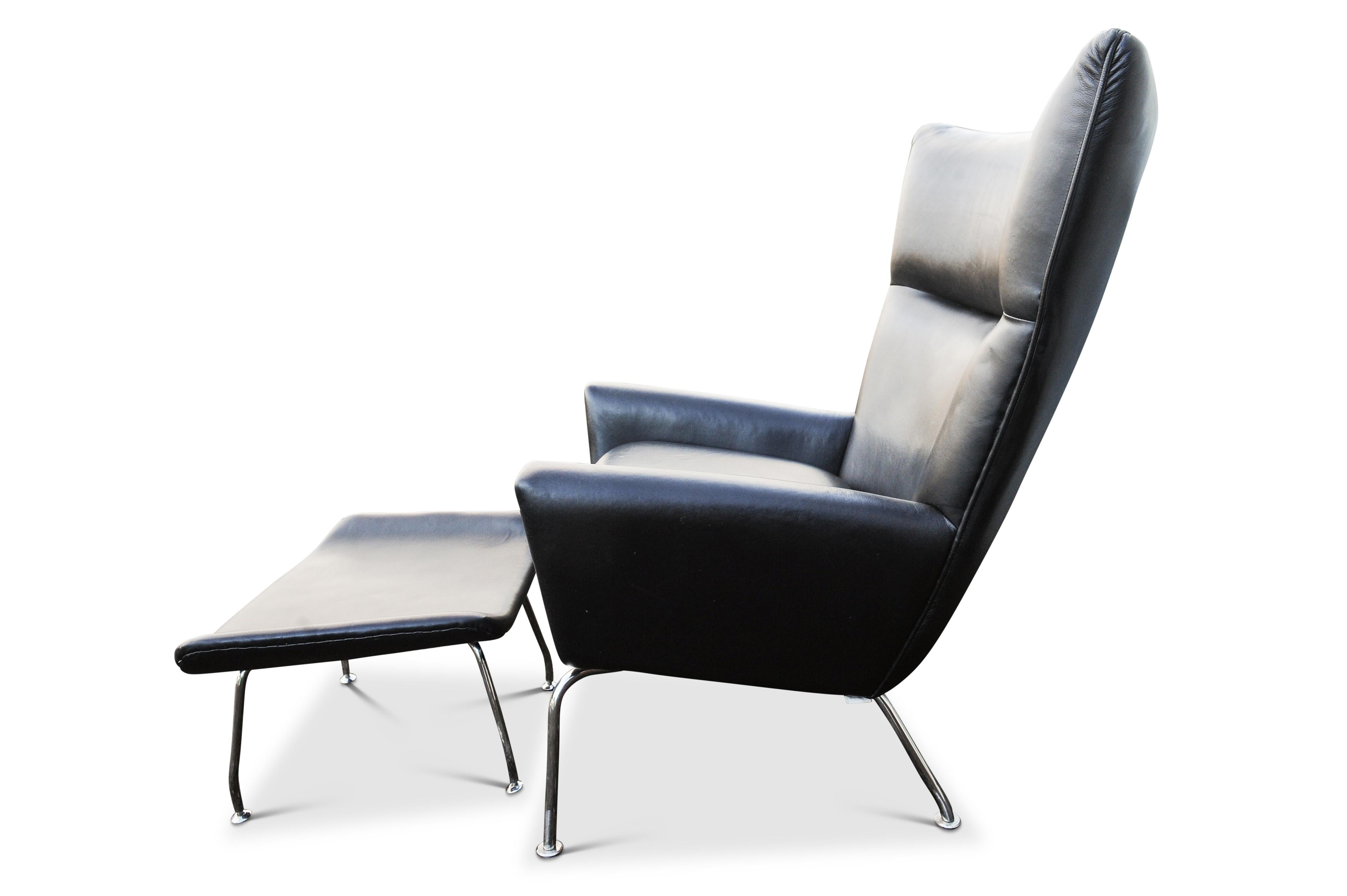 Iconic Hans J Wegner CH445 Design Style Black Leather and Stainless Steel Wing Armchair & Matching Ottoman Set

This is a  version in the style of Hans Wegner, no makers marks or labels.




