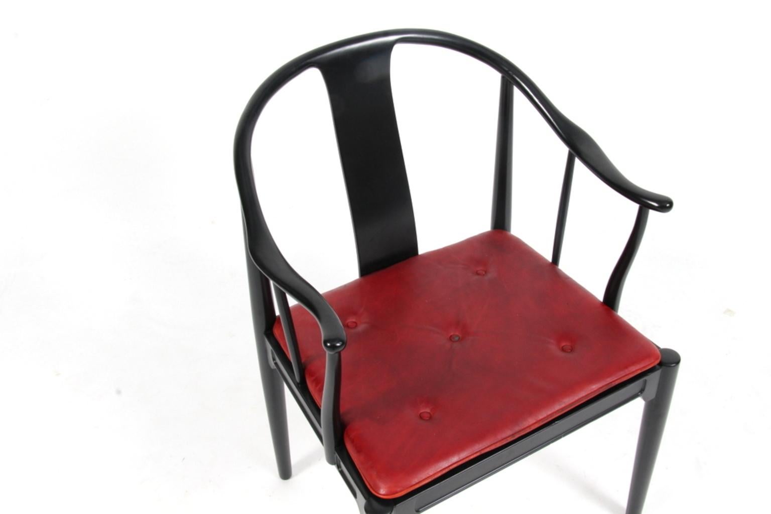 Hans J. Wegner famous and beautiful chair is an adaptation of an old Chinese chair of the Ming dynasty; “China Chair”. A very comfortable armchair made in newly lacquered black wood. Loose seat cushions upholstered with patinated Indian red leather,