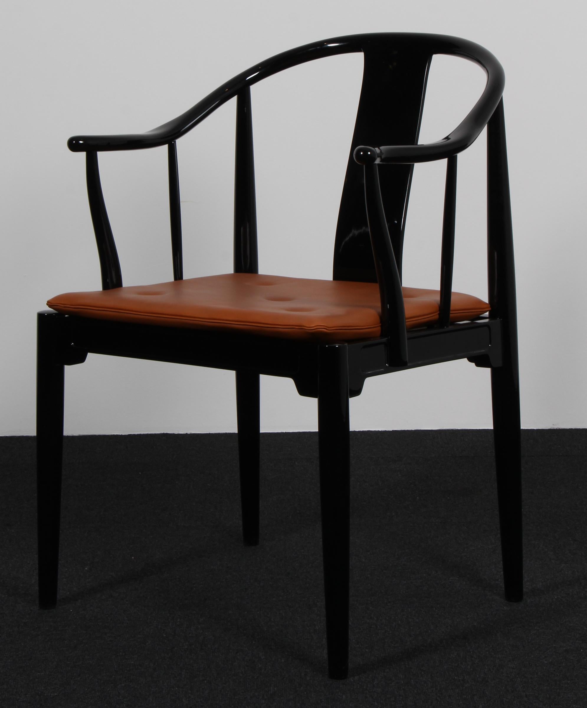 Hans J. Wegner famous and beautiful chair is an adaptation of an old Chinese chair of the Ming dynasty; “China Chair”. A very comfortable armchair made in black painted. Loose seat cushions new upholstered with indian red aniline leather, fitted