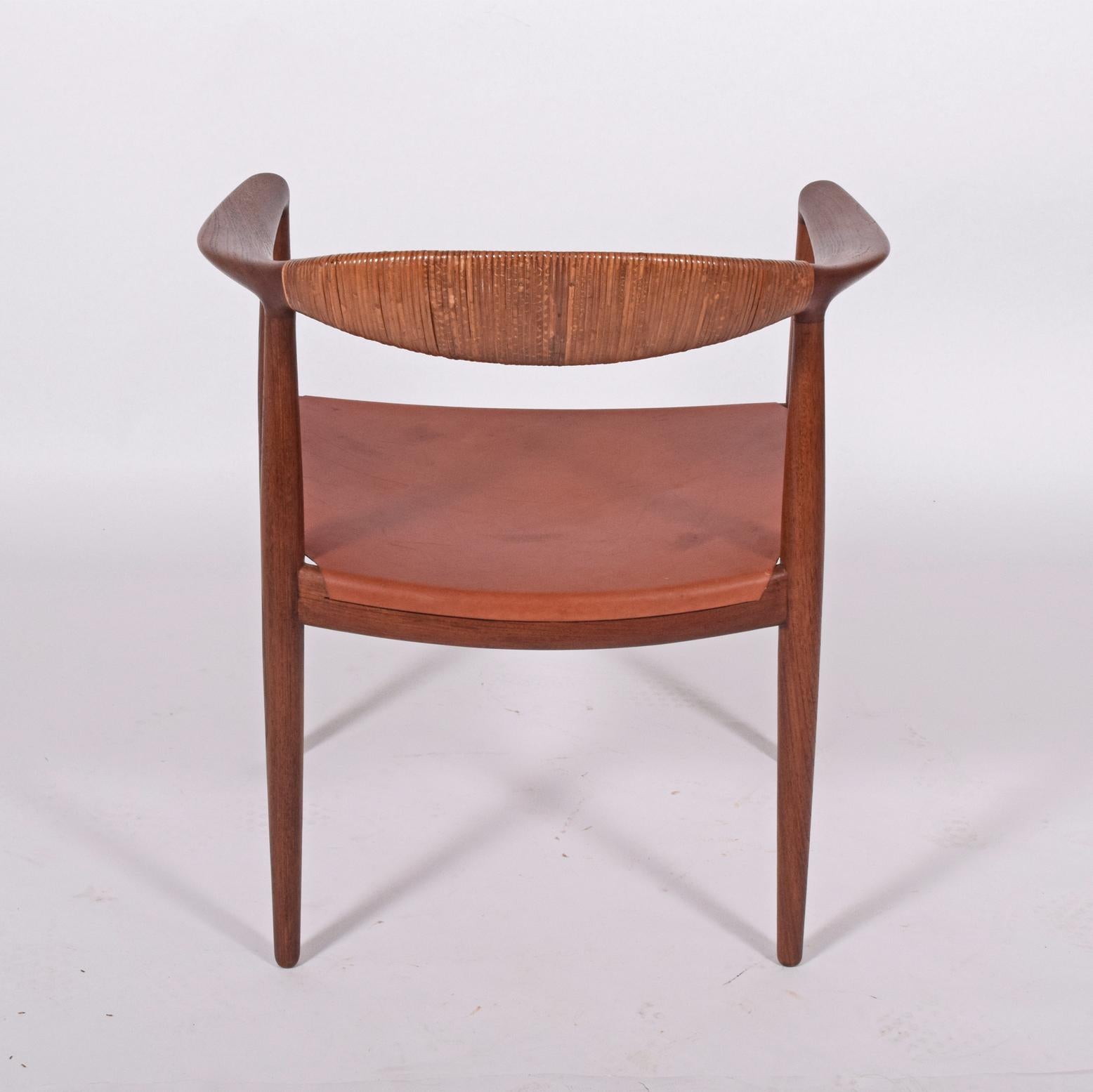 Solid teak early Hans Wegner 501 armchair with cane back leather seat instead cane impressed mark on the stretcher.