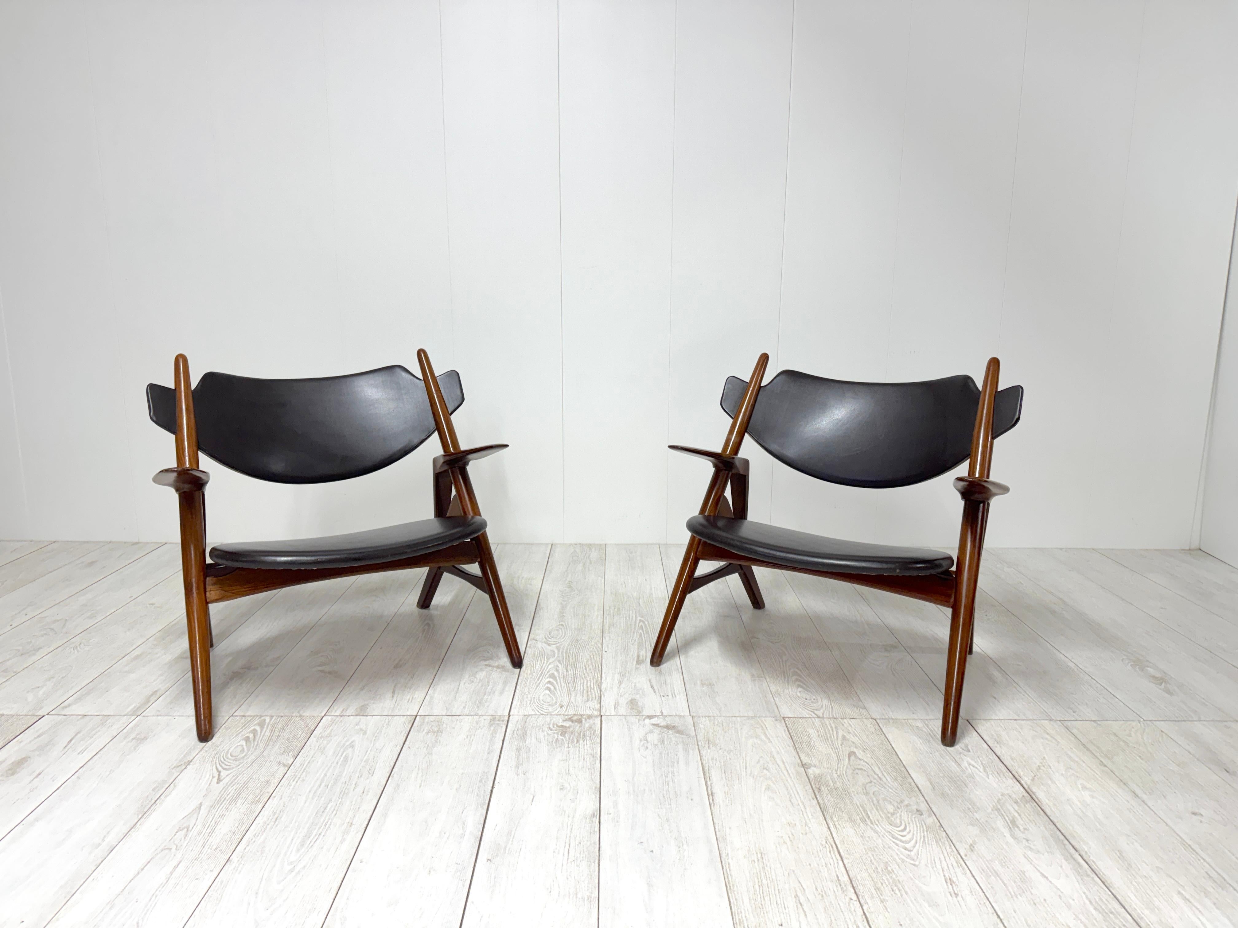 Bellissima coppia di poltroncine con struttura in legno e seduta e schienale in skay.
Questo modello incorpora molte delle caratteristiche di design del maestro. 
 La predilezione di Wegner per la creazione del perfetto equilibrio tra forma e