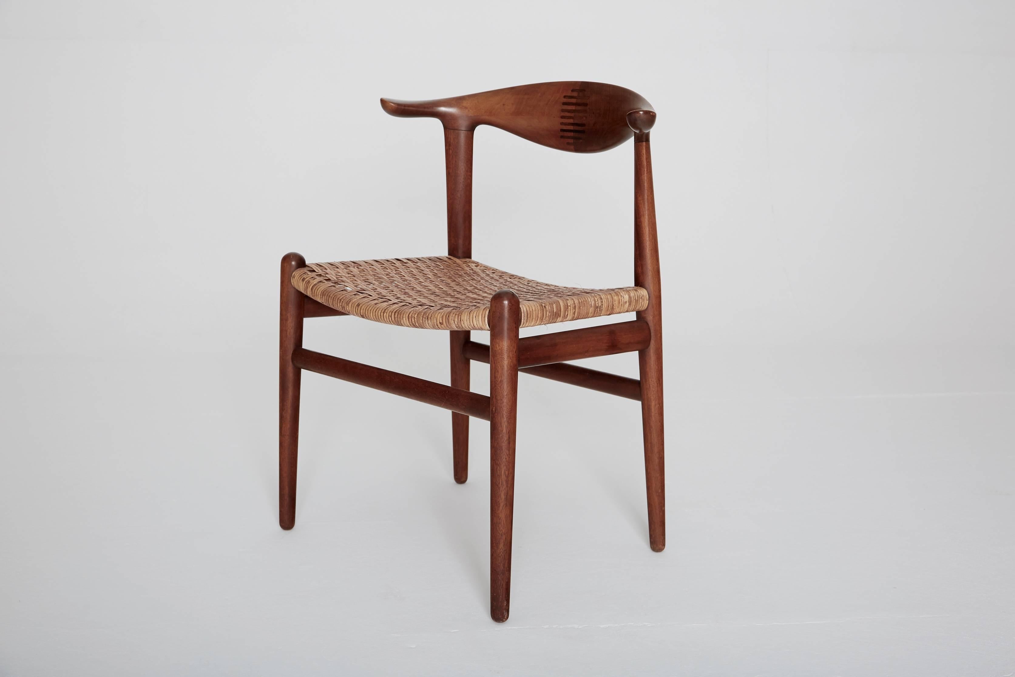 Hans Wegner cow horn (Kohornstol) Chairs model JH 505, made by Johannes Hansen, Denmark. Teak and rosewood inlay, with cane seats. A pair is available but the price it per chair and they can be sold individually.