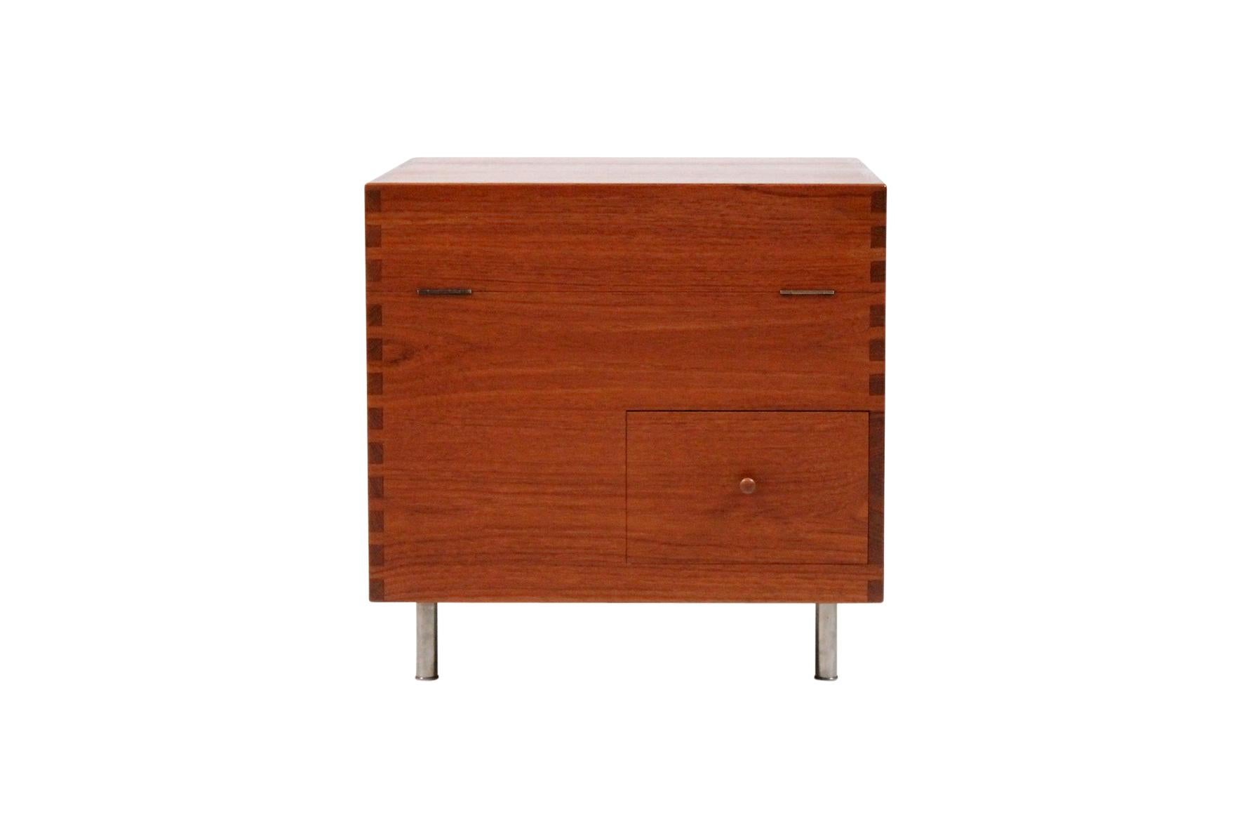 Hans Wegner teak cube bar crafted by Andreas Tuck, 1960s.

Hinged top and single drawer with exposed dovetail construction raised on chrome plate steel legs. In very good condition.
