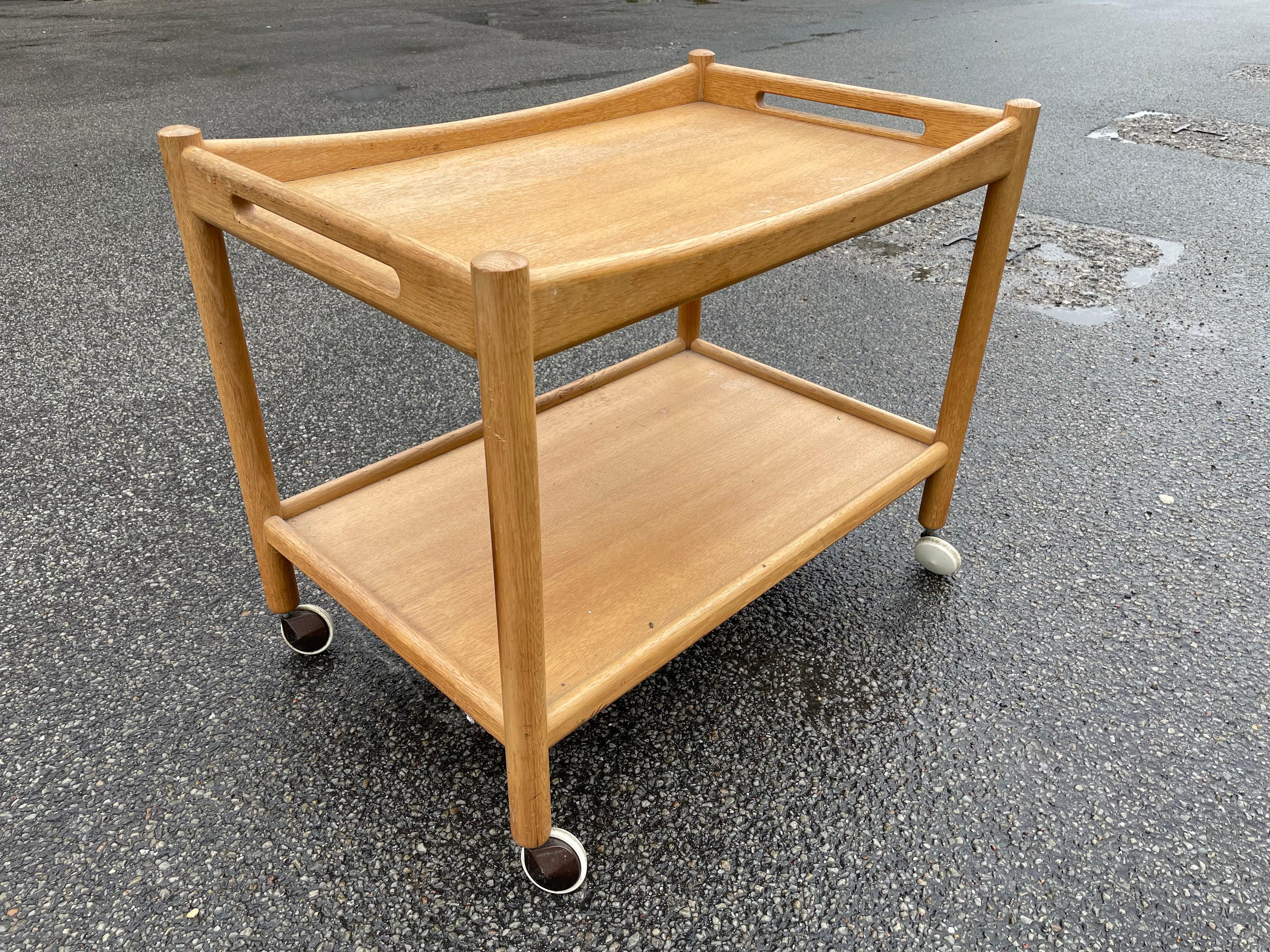 Midcentury bar cart in oak designed by Hans Wegner, 1950s
A rare midcentury Danish modern oak bar cart or serving trolley designed by Hans Wegner for Andreas Tuck. The cart features gorgeous teak wood grain and Minimalist Danish design. It sits on