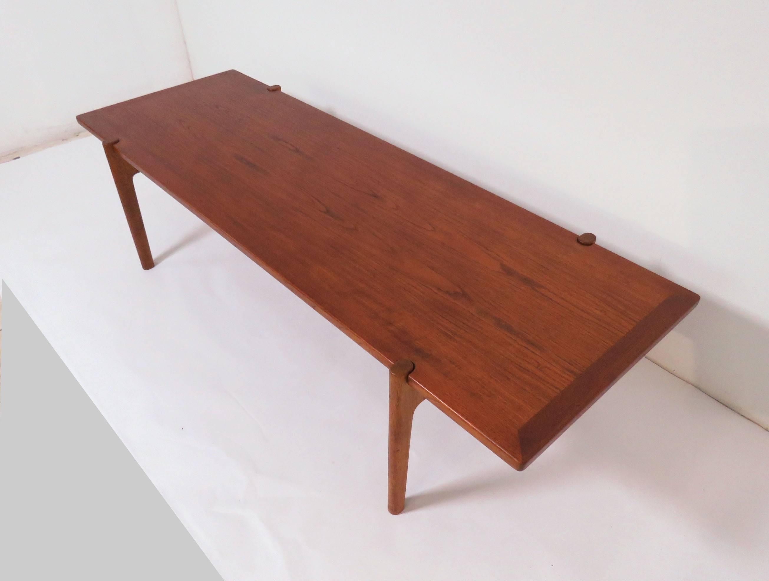 Versatile coffee table with flip top surface featuring black laminate on one side, fully grained teak on the other. Designed by Hans Wegner for Johannes Hansen, Denmark, circa 1960s. 

Measures: Overall length just over 6 feet (72 5/8