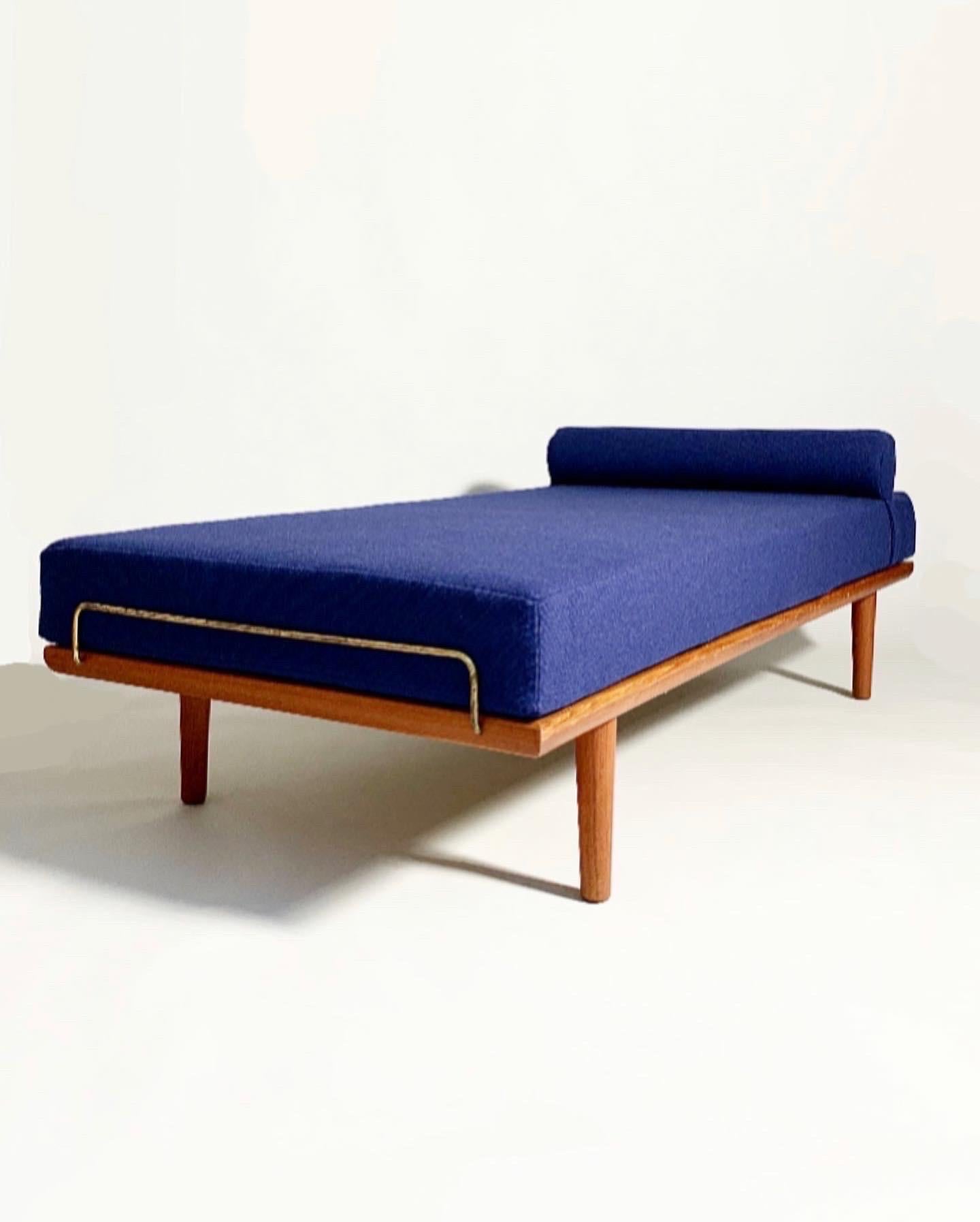 Hans Wegner daybed, model No. GE-19 for Getama in Denmark in the 1950s.

Solid frame in teak with mattress framing brass details on both sides. New mattress with adjustable neck roll, upholstered in Kvadrat Hallingdal, color 764.

Measures: