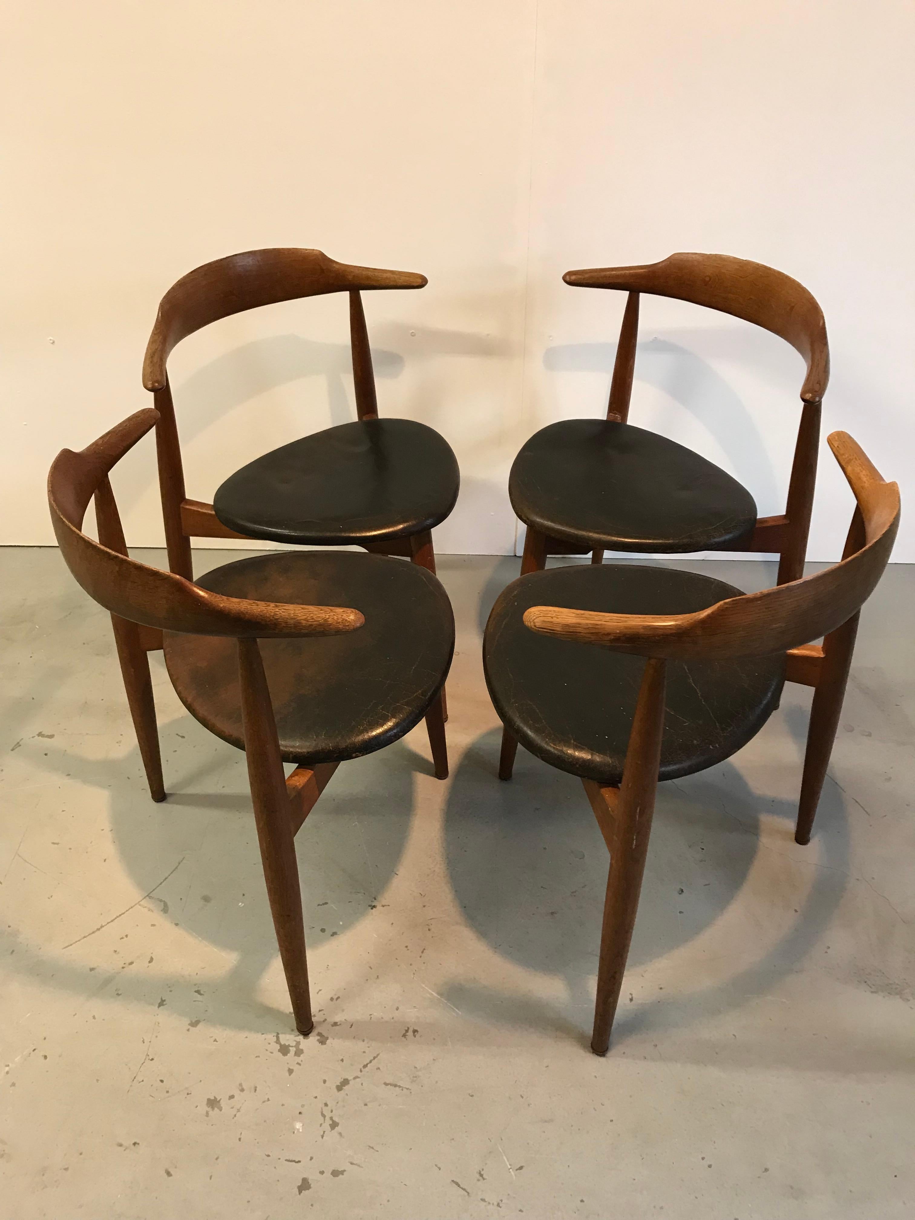 4 chaises de salle à manger Fritz Hansen, conçues par Hans Wegner dans les années 1950. Bois de chêne avec revêtement en cuir noir.
Très bon état vintage.