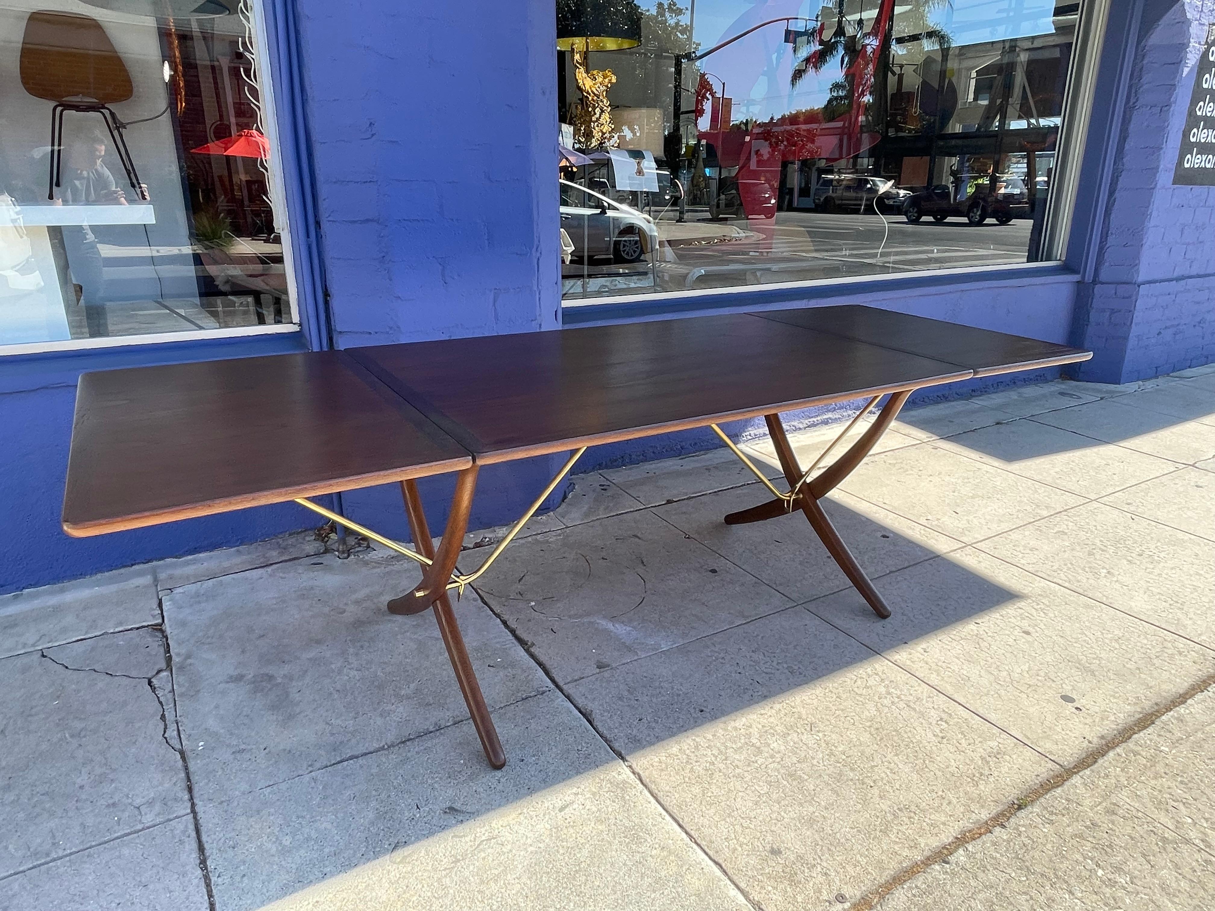 Beautiful Hans Wegner for Andreas Tuck drop-leaf dining table, model AT-304, in perfect condition. Denmark, circa 1960. Teak, oak, and brass. Branded maker's marks 'Fabrikat Andr. Tuck Arkitekt Hans J Wegner Denmark — Made in Denmark. Overall width