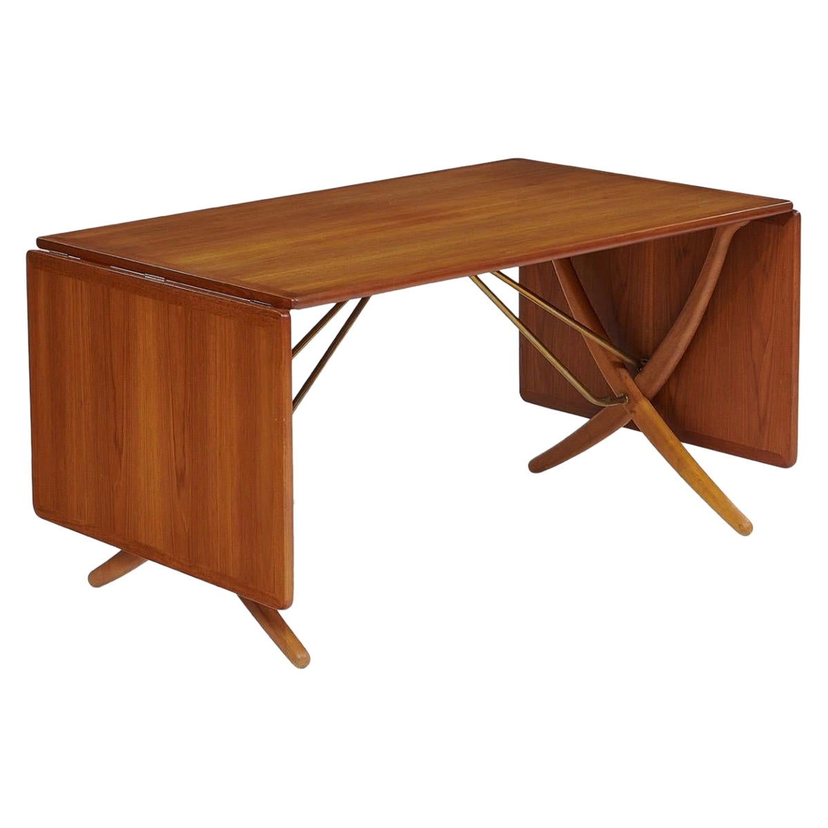 Beautiful Hans Wegner for Andreas Tuck drop-leaf dining table, model AT304, in perfect condition. Denmark, circa 1960. Teak, oak, and brass. Branded maker's marks 'Fabrikat Andr. Tuck Arkitekt Hans J Wegner Denmark — Made in Denmark. Overall width