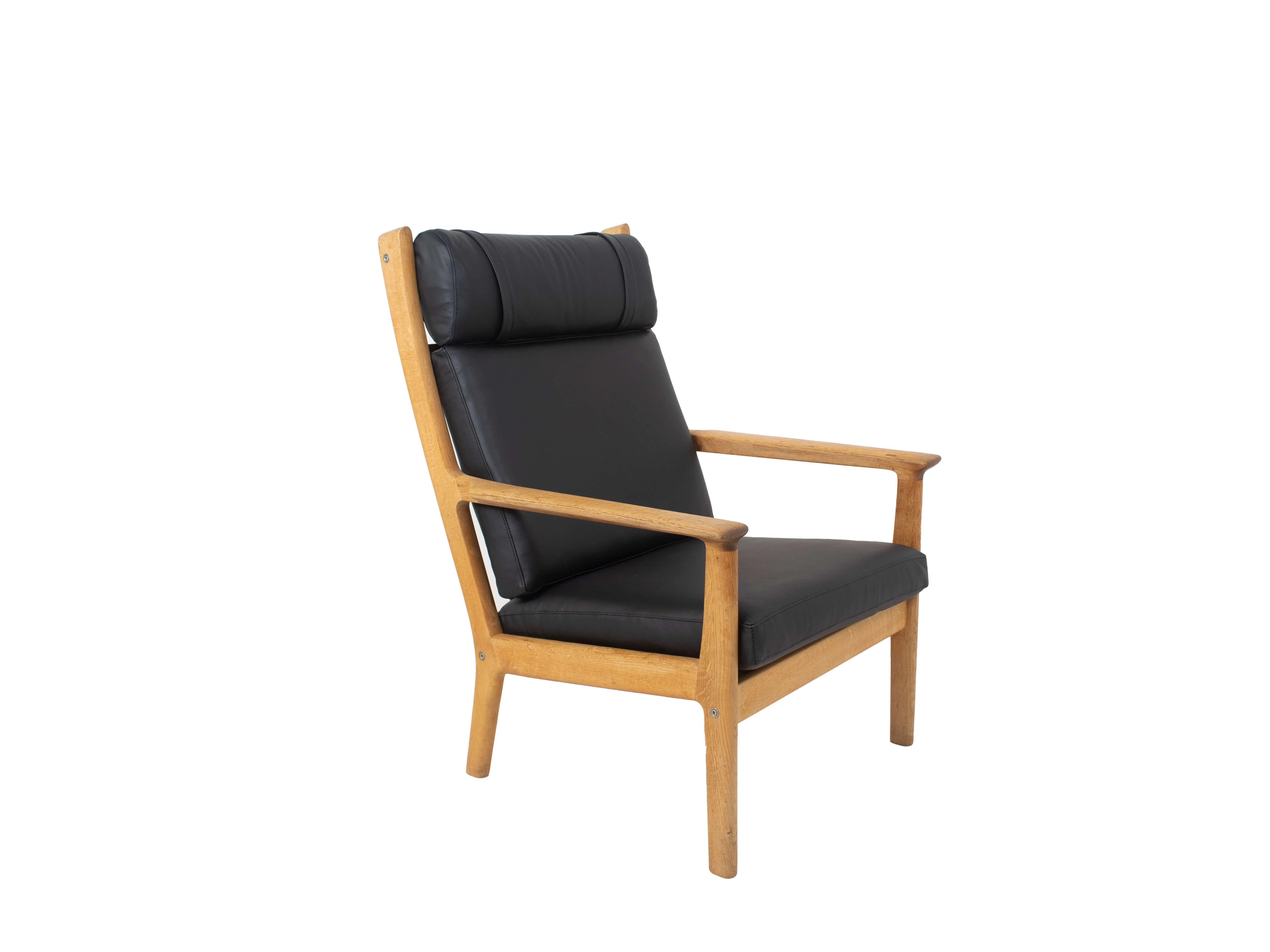 Robuster Hans Wegner Fauteuil GE 265 für GETAMA in Eiche und schwarzem Leder, 1980. Dieser Stuhl ist neu mit schwarzem Leder gepolstert. Es ist sehr bequem und in gutem Zustand. Der Stuhl hat ein eindeutiges Zuordnungszeichen.