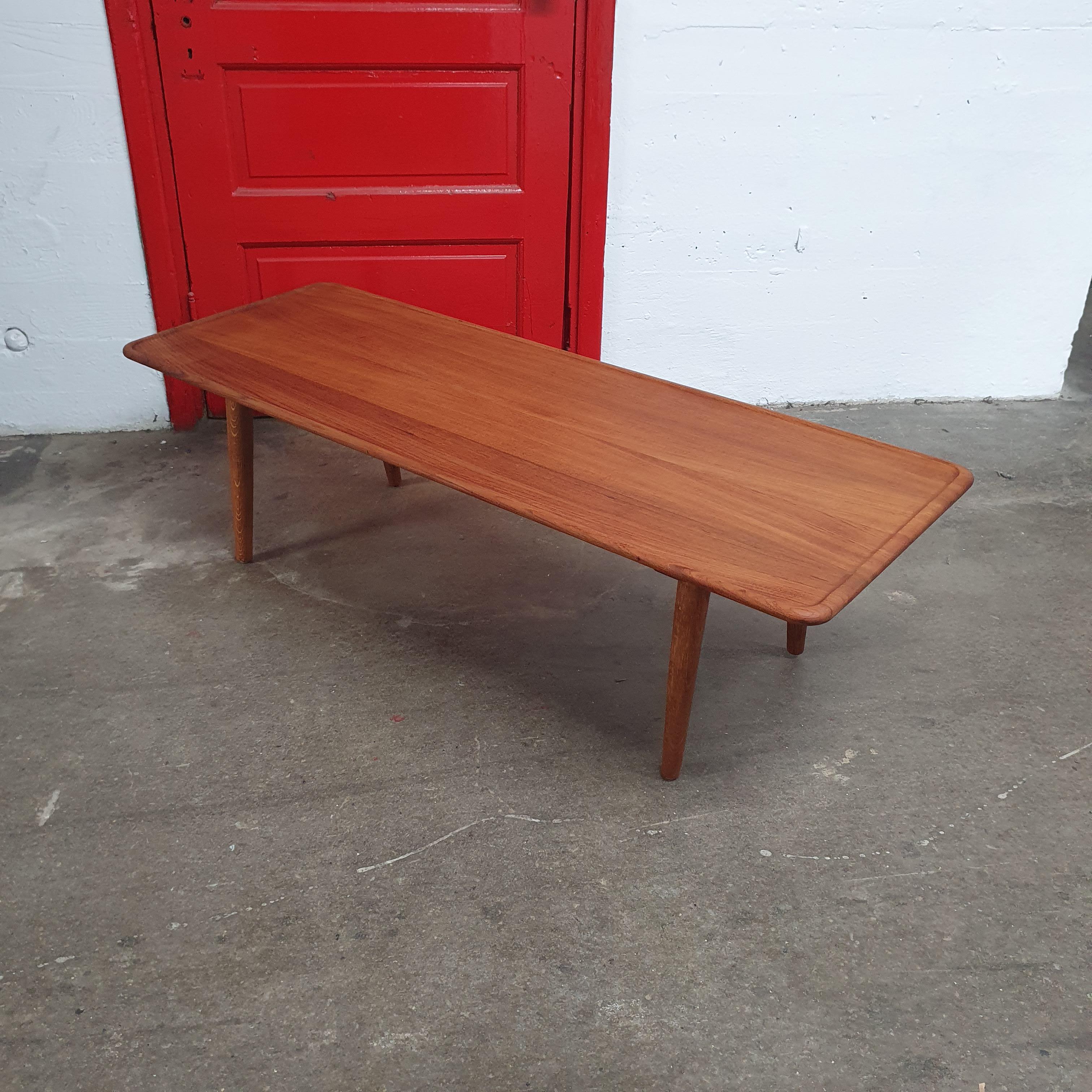 Beautiful Teak and Oak Hans Wegner coffee table for Andreas Tuck,model AT-11. features teak top with raised lip and round tapered Oak legs. Classic danish modern design. marked on underside.