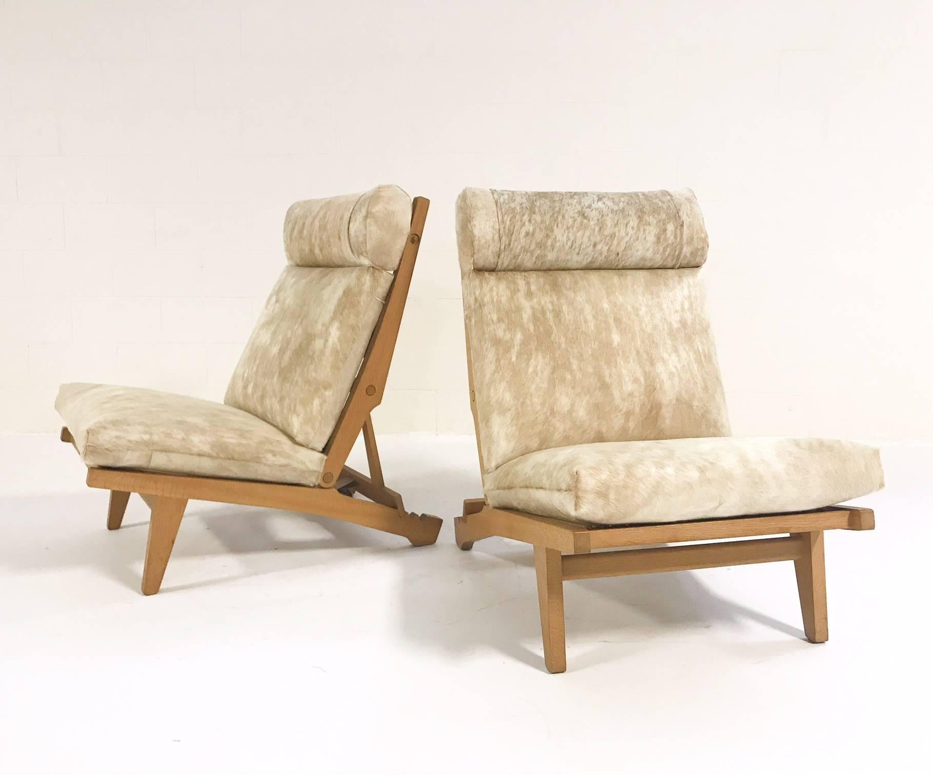 This coveted pair of solid oak lounge chairs was designed by the incomparable Hans Wegner for AP Stolen, with whom he worked for many years. We chose gorgeous palomino and white Brazilian cowhides to complement the lightness and beauty of the oak.