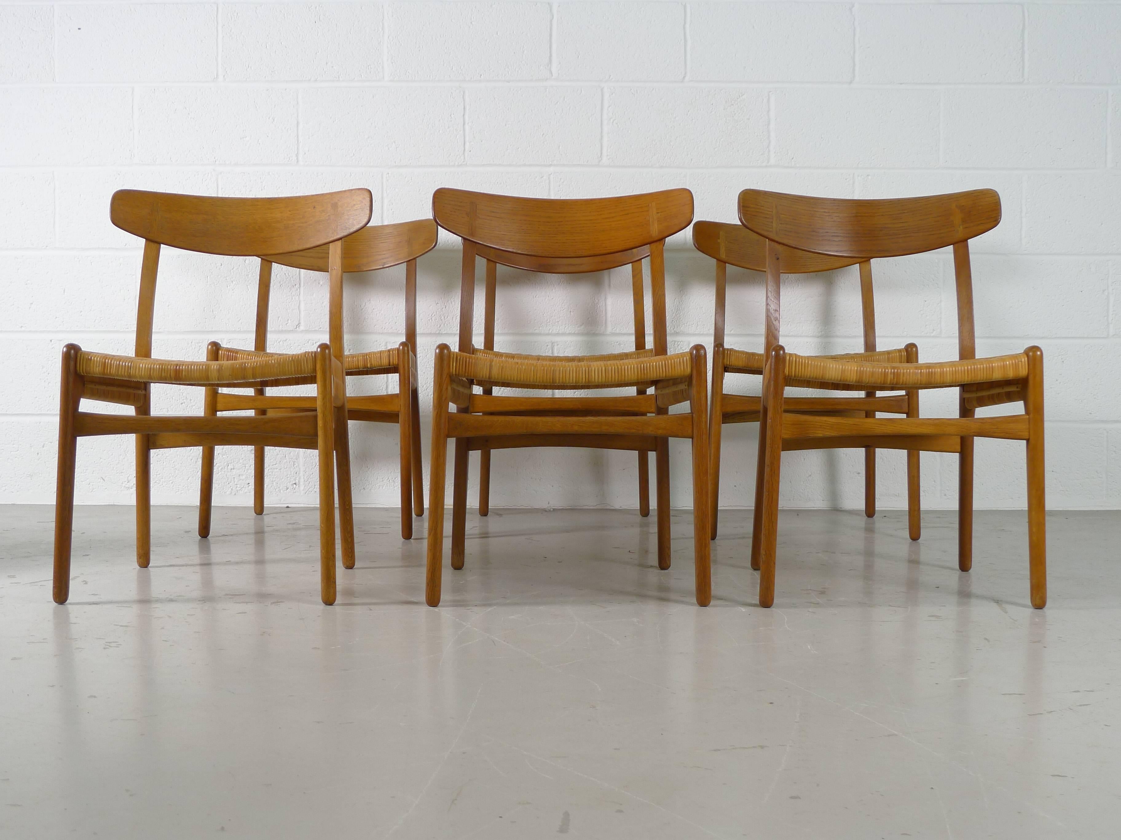 Hans Wegner designed for Carl Hansen and Sons, Denmark circa 1951. A set of six chairs in Oak with cane seats.

Typical detailing and lovely pattina.
